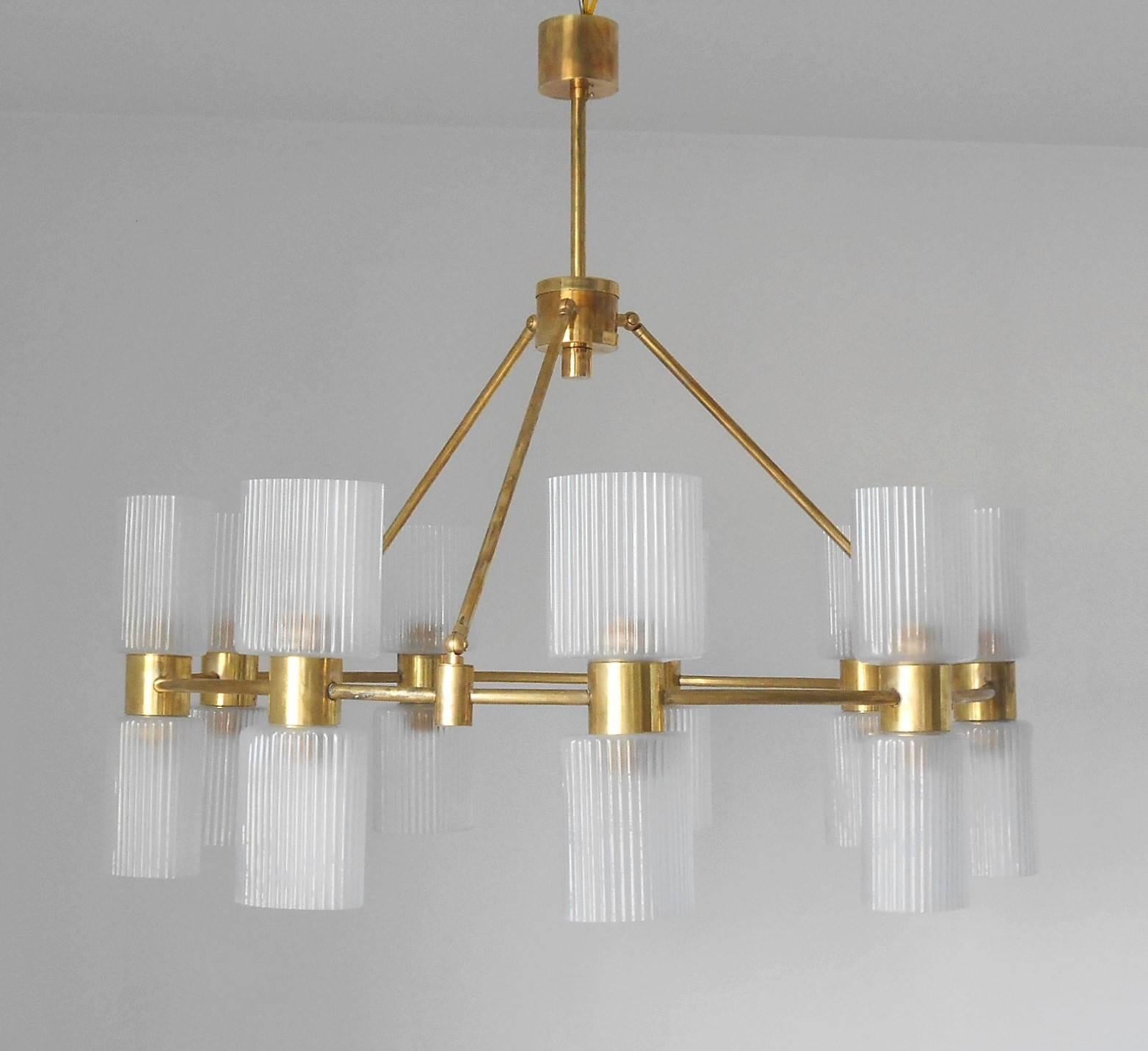 Frosted ribbed glass shades mounted on brass structure, in the style of Stilnovo.
18 light sockets / wired for the US.
 A pair available ; price listed is for one chandelier.