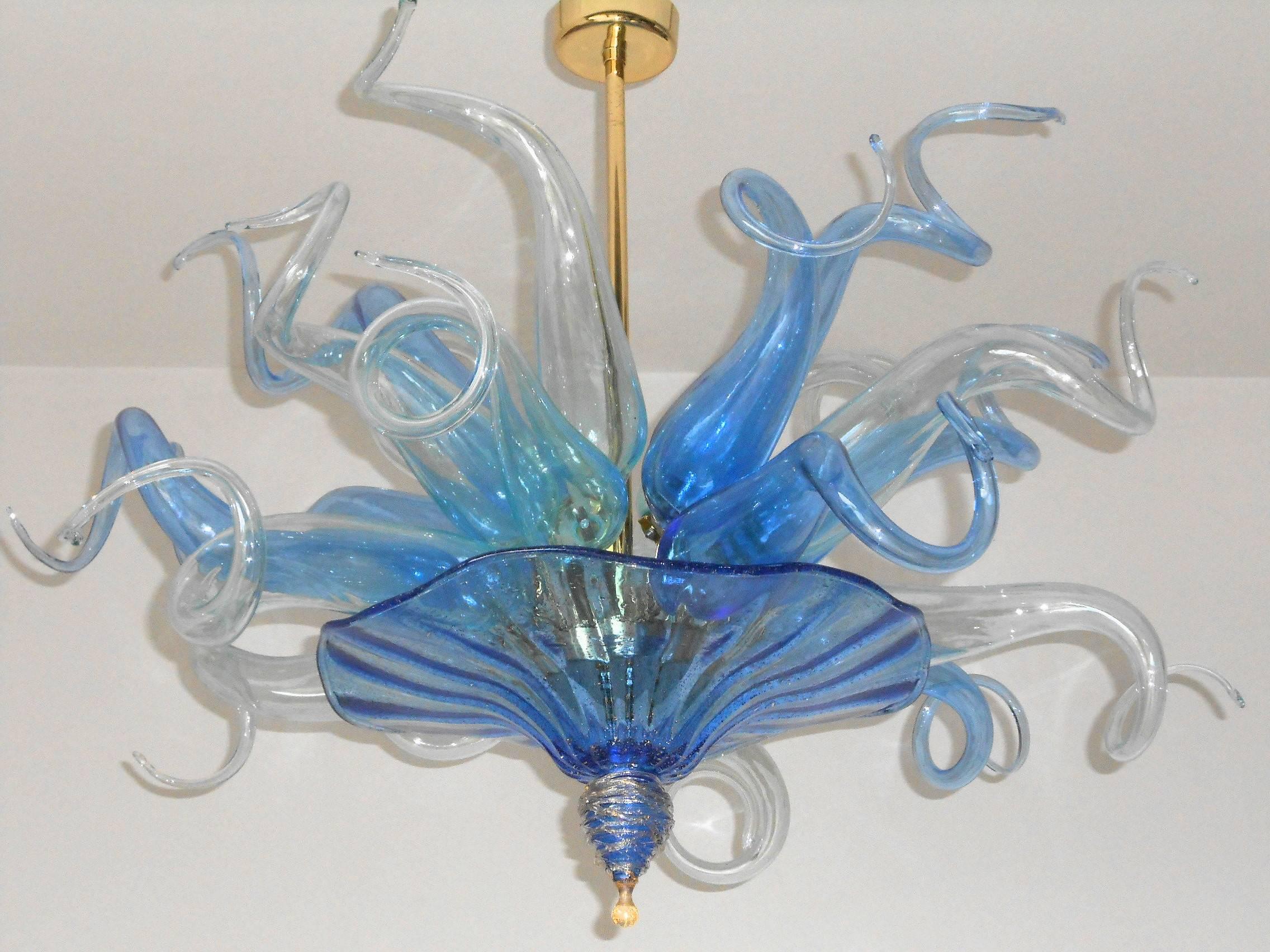 Blue and clear glass, base plate and finial with 24-karat gold infused.

Five light sockets / wired for the US.