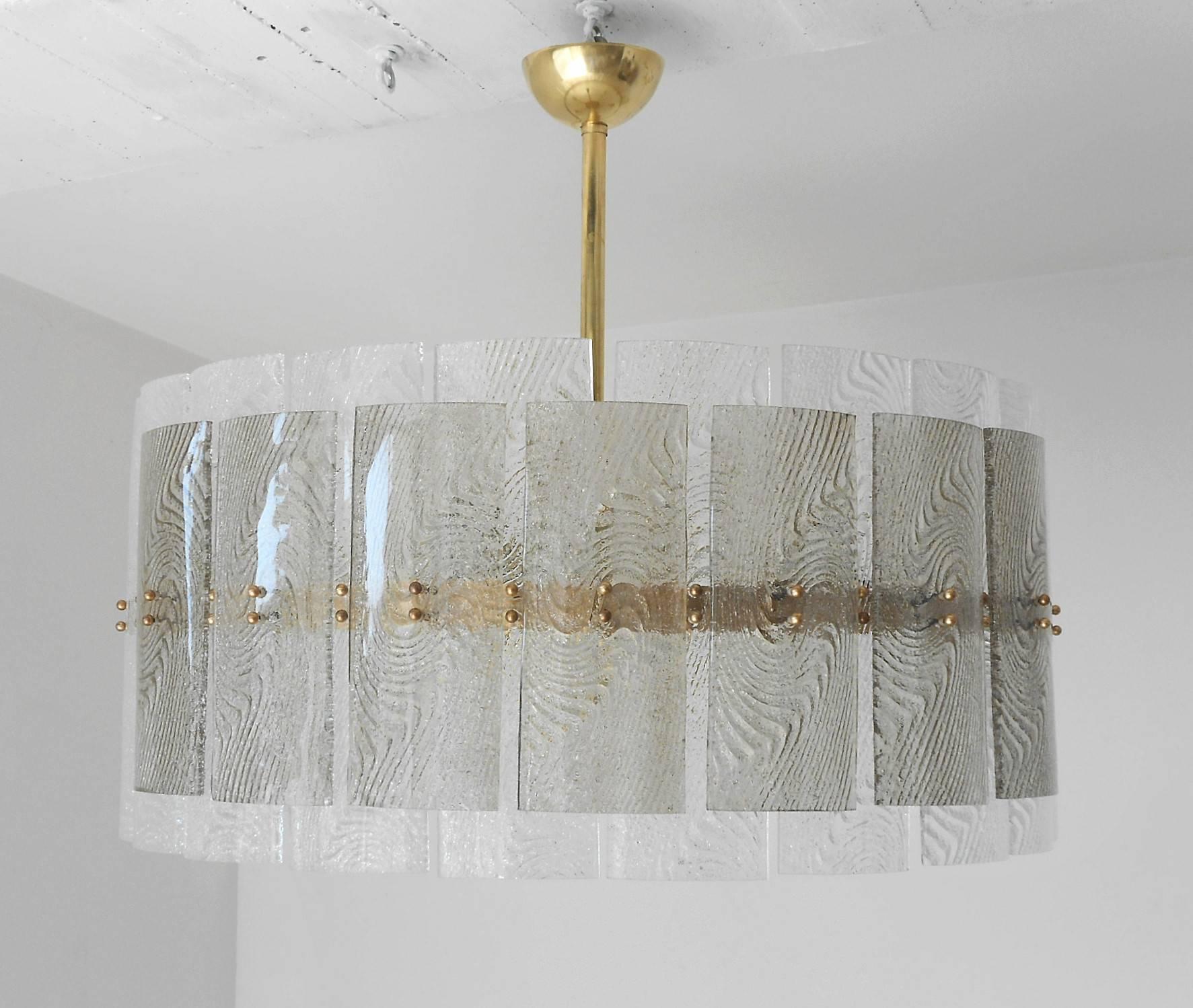 Drum shape chandelier with textured clear and smoky Murano glass tiles mounted on brass structure. Frosted glass diffuser.

Six standard base light sockets/wired for the US.