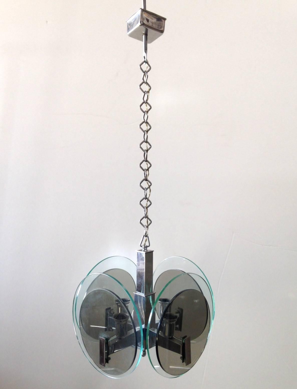 Vintage Italian pendant with smoky and clear glass disks layered on chrome frame / Designed by Cristal Art circa 1960’s / Made in Italy
4 lights / E12 or E14 type / max 40W each
Diameter: 11 inches / Height: 10 inches plus chain and canopy
1 in