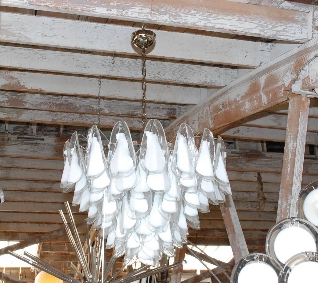 Vintage Italian chandeliers with milky white Murano glass petals, mounted on nickel frames / Designed by Vistosi circa 1960’s / Made in Italy
13 lights / E26 or E27 type / max 60W each
Diameter: 32 inches / Height: 22 inches plus chain and canopy
2