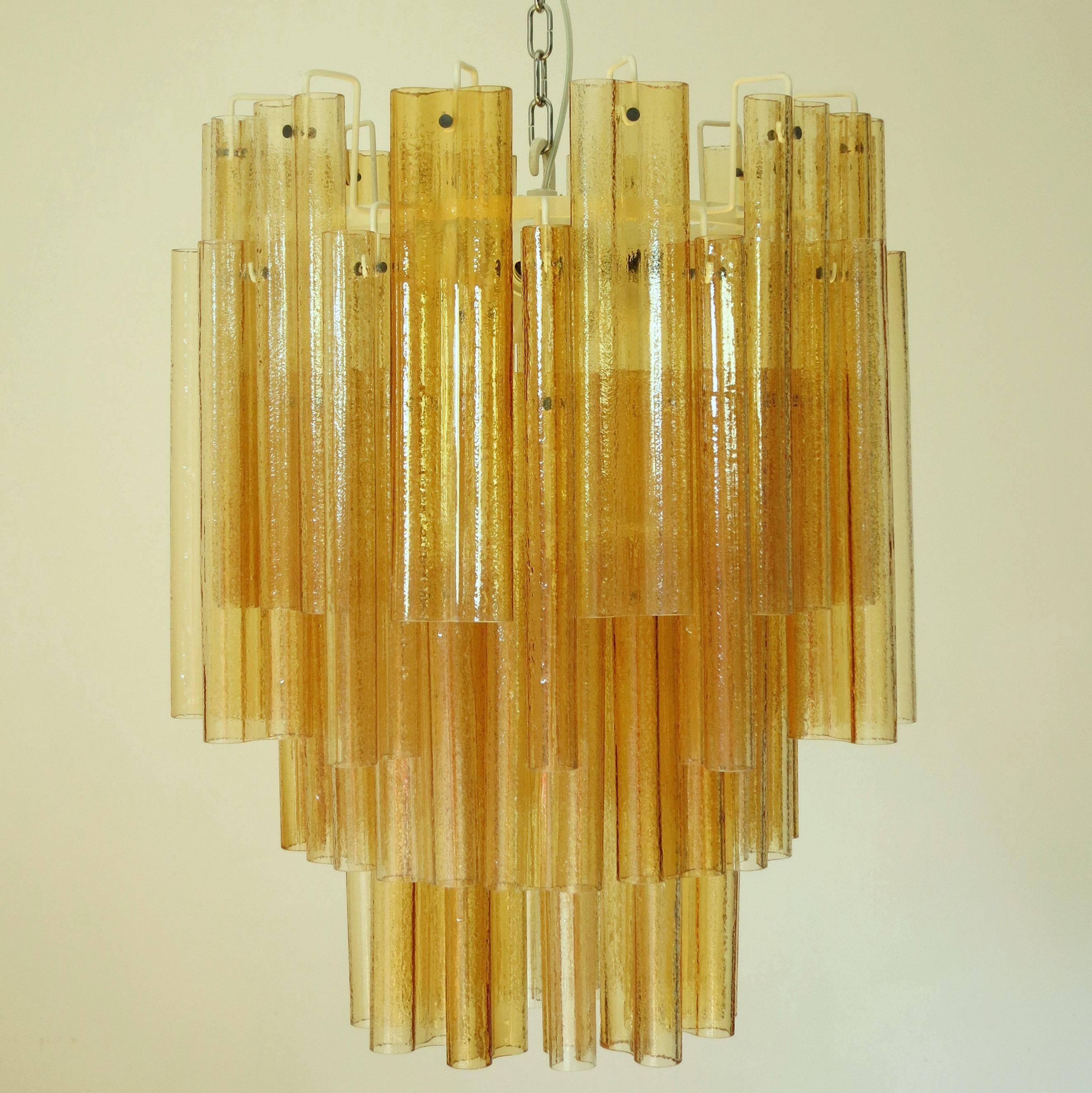 Original Italian vintage chandelier with hand blown amber Murano glass tubes, mounted on painted white metal frame / Attributed to Venini circa 1960s / Made in Italy
Measures: Diameter 26 inches / height 32 inches plus chain and canopy
13 lights /