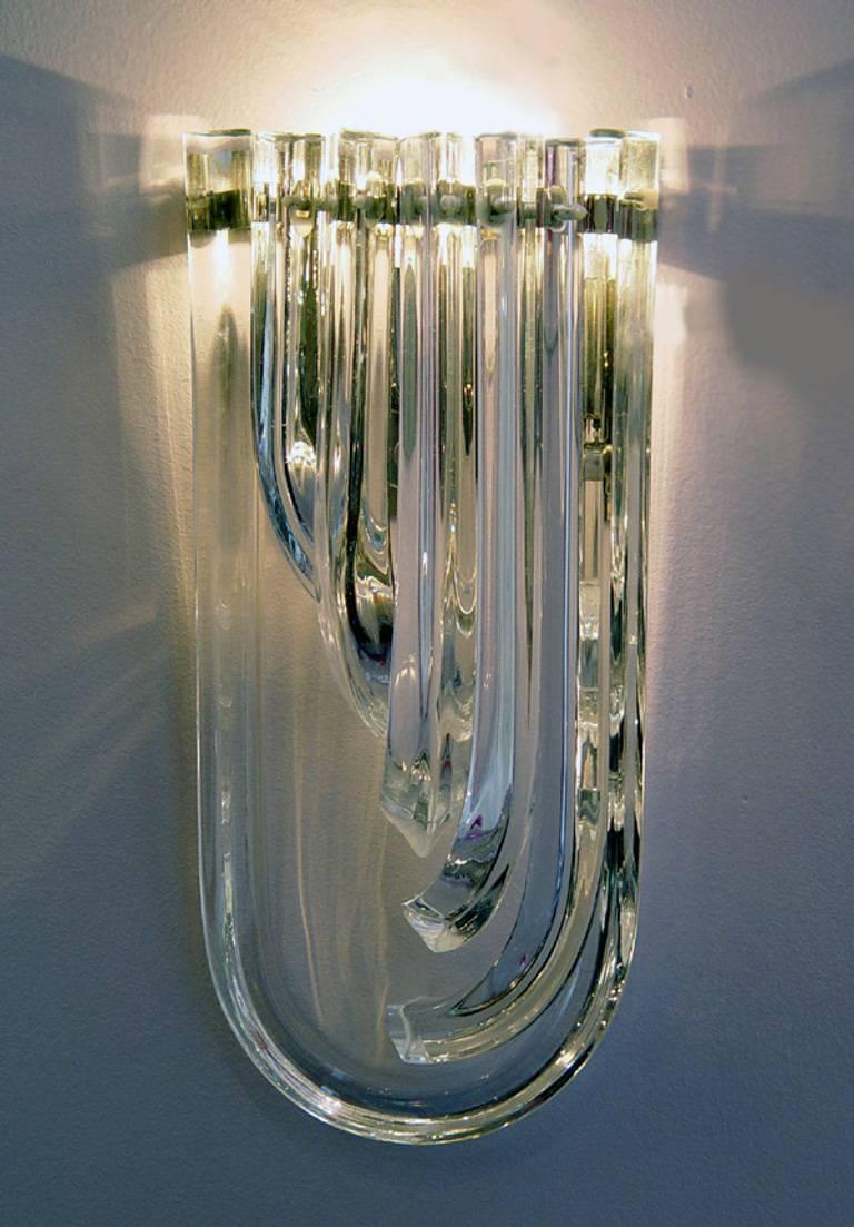 Italian wall lights with clear Murano glasses hand blown into descending curved shapes, crafted into three points in Triedri technique, mounted on nickel back plates / Designed by Venini, circa 1960’s / Made in Italy 
1 light / E12 or E14 type / max