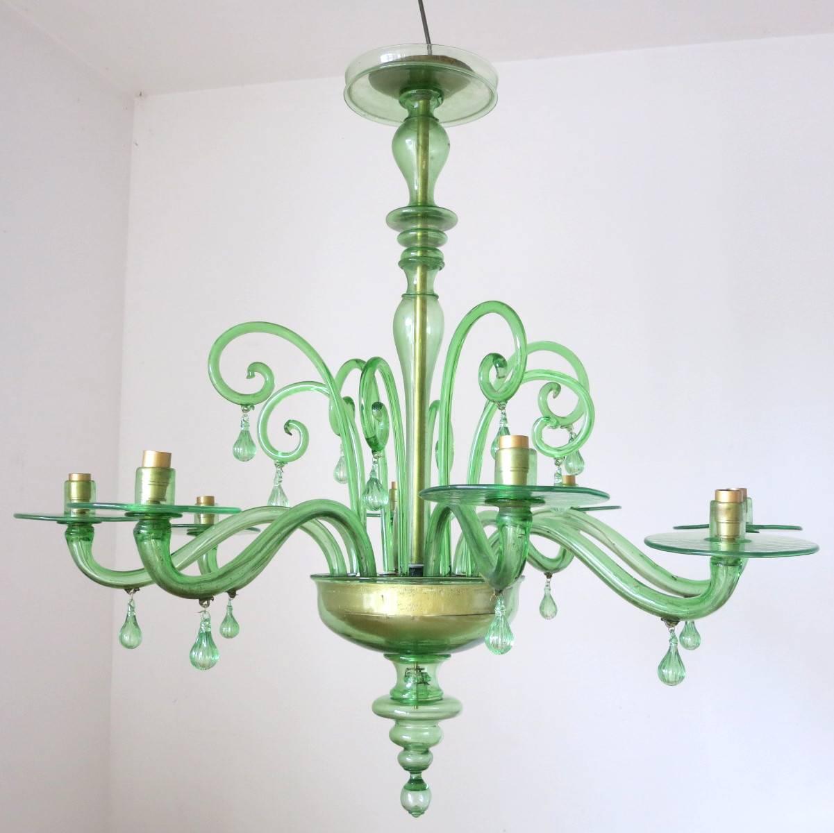 This emerald green Murano glass chandelier was mouth blown in the 1930s by skilled glass Maestros for Venini.

Originally made for burning candles, it has been newly rewired with eight candelabra light sockets (E12 type, max 60 W each).

It's in