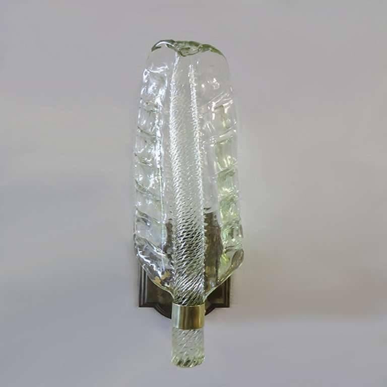 Elegant pair of Murano glass leaf sconces with sold brass wall mounts, designed and handblown by Barovier e Toso in the 1960s.

Glass is in perfect condition.
Brass mounts are slightly oxidized by the age (image 6).
Rewired with one candelabra