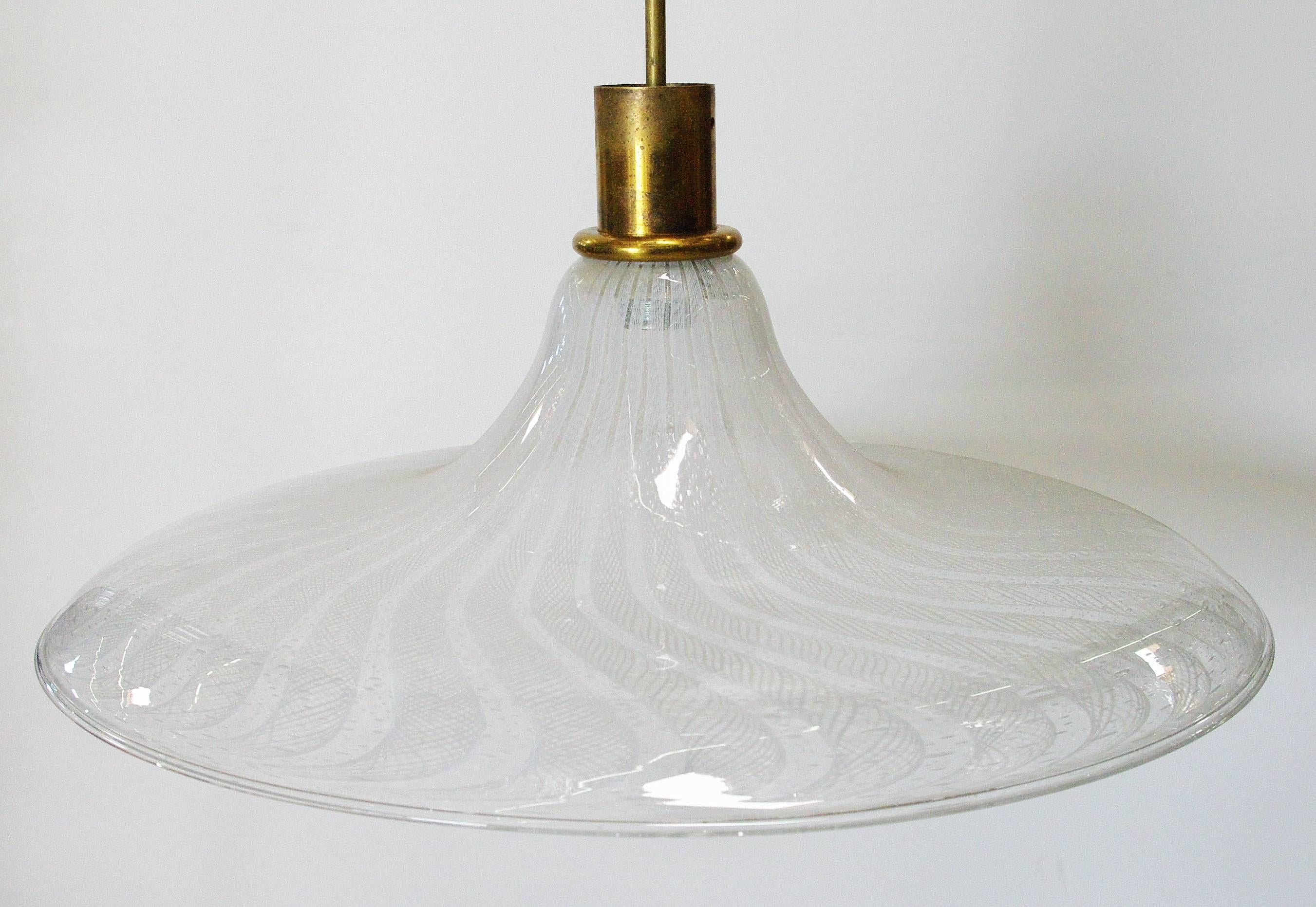 Vintage Italian pendant with clear Murano glass shade hand blown with bubbles within the glass and interlaced frosted patterns using Bollicine and Filigrana techniques, mounted on brass hardware / Designed by Venini circa 1960’s / Made in Italy
1