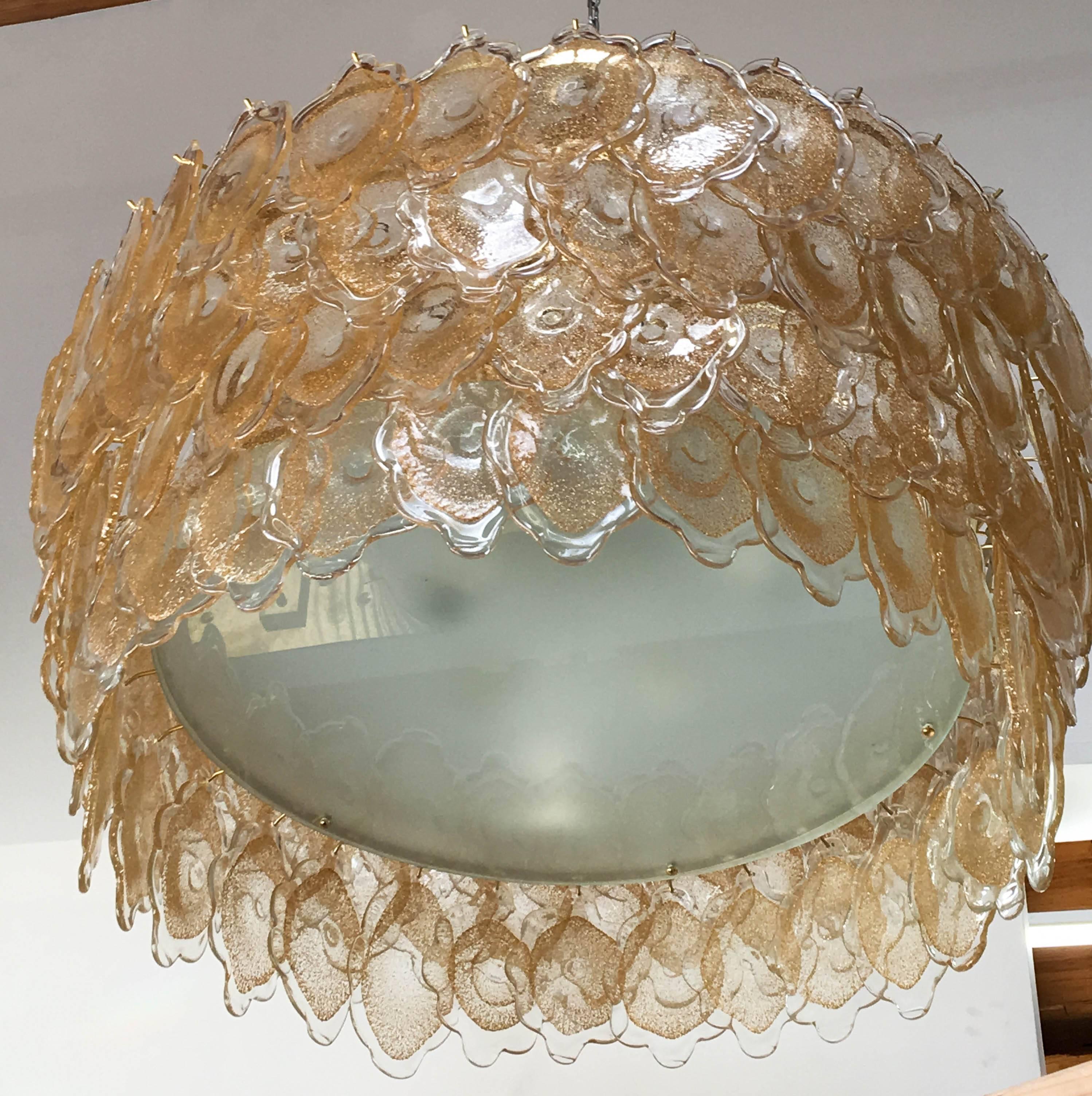 Vintage Italian chandelier with 128 uniquely hand blown 24 karat gold infused Murano glasses, mounted on a brass drum-shaped frame that creates a gold cloud effect, and frosted glass diffuser / Designed by Mazzega circa 1960’s / Made in Italy
12