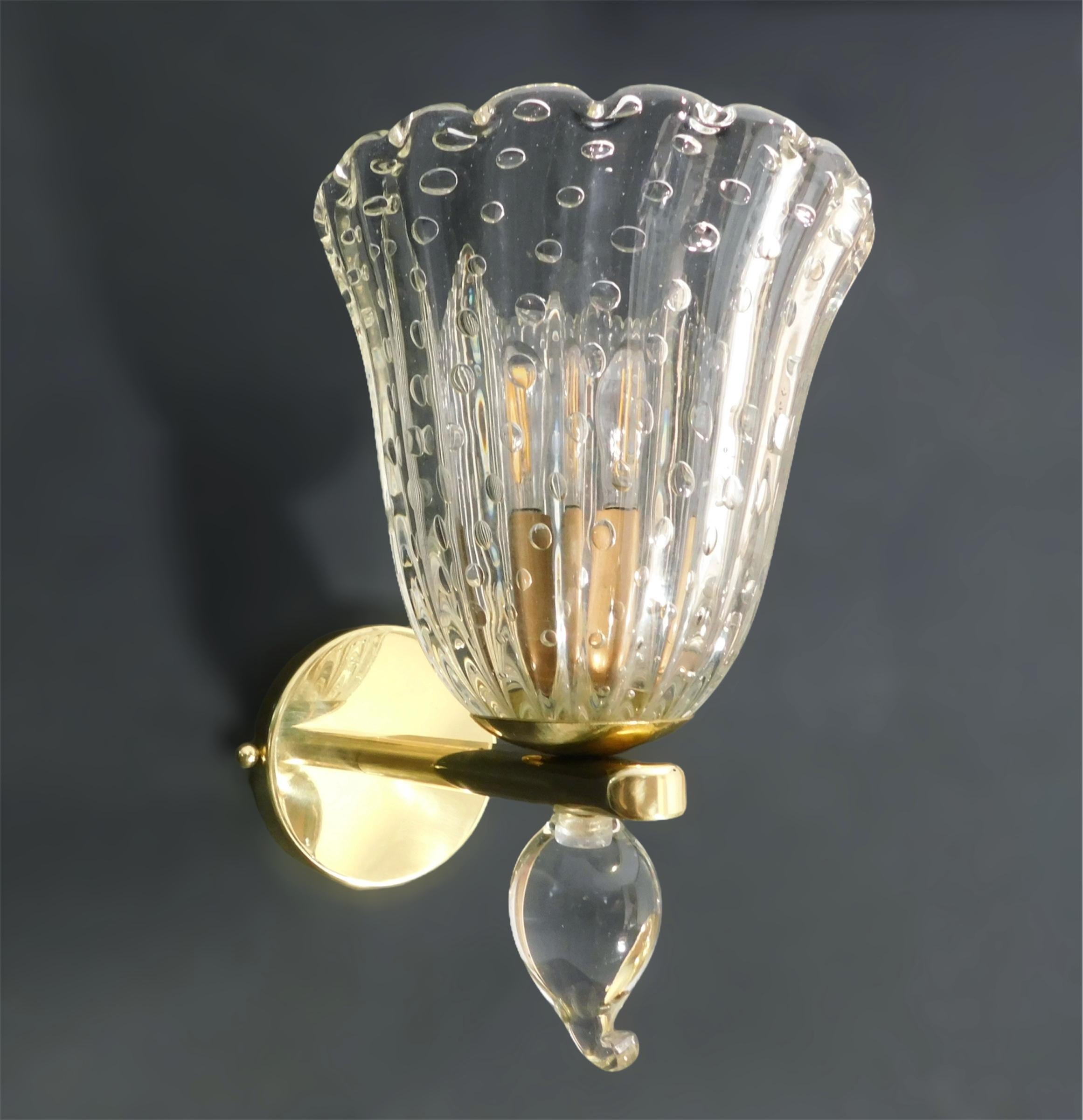Vintage Italian wall lights with clear Murano glass cups hand blown with bubbles inside the glass using Bollicine technique and small glass finials, mounted on brass frames / Made in Italy, circa 1950s
Measures: Height 10 inches, width 7 inches,