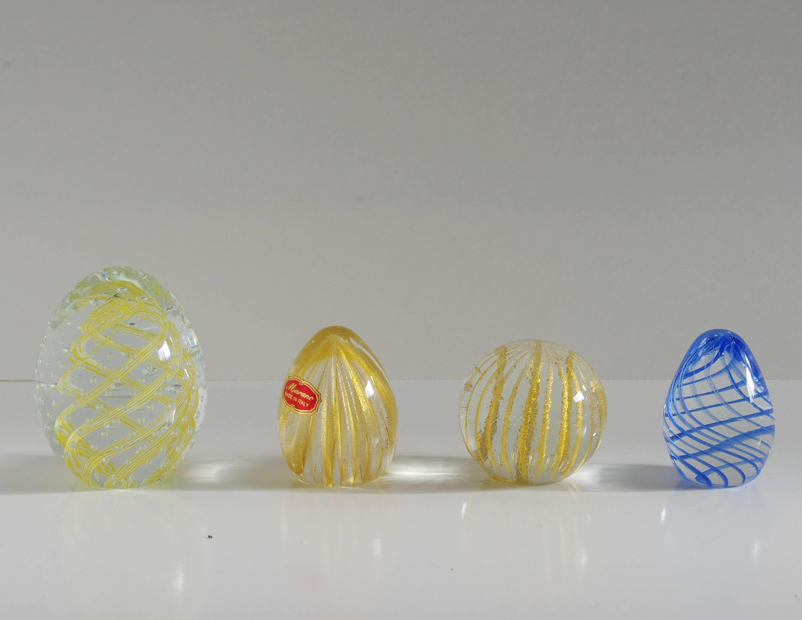 Collection of four paperweights  made with clear, gold, and blue Murano glass hand blown in beautiful stripped patterns. Two of the four paperweights have original stickers / Made in Italy in the 1960's
Diameter for each piece range between 2.5
