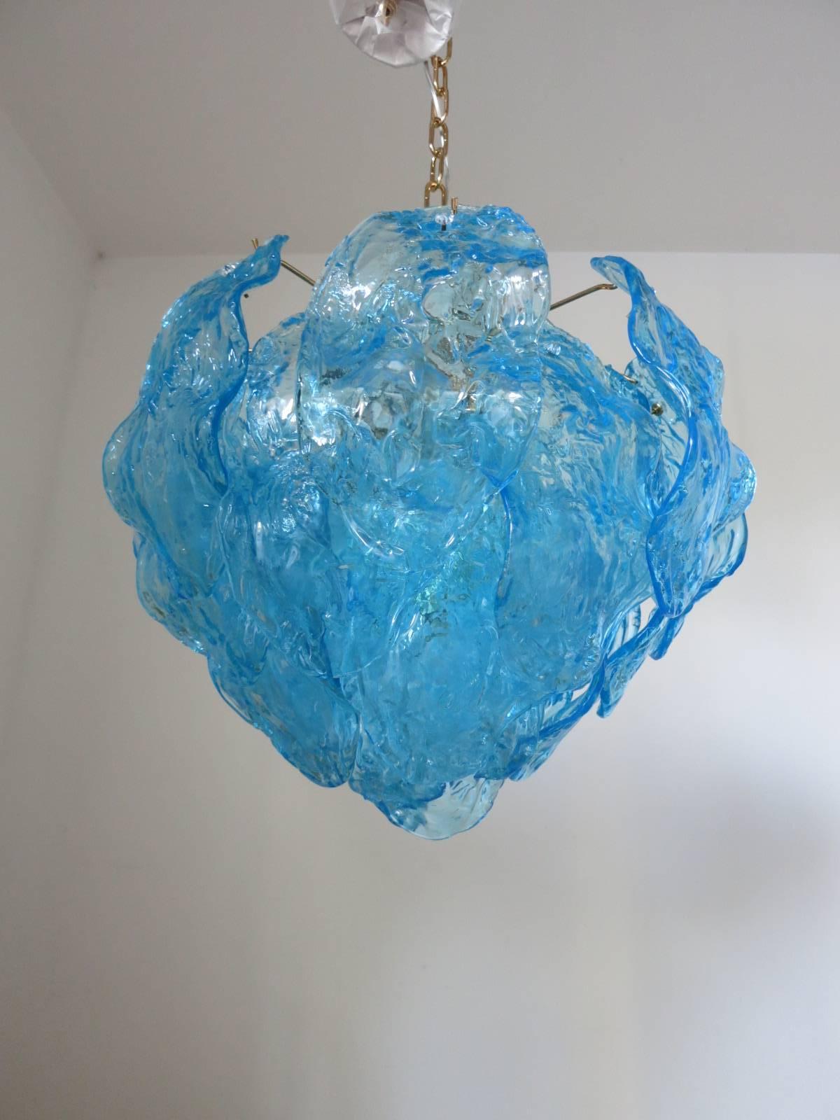 Italian vintage chandelier with hand blown aqua blue Murano glass leaves, mounted on a brass frame / Designed by Mazzega circa 1960’s / Made in Italy 
4 lights / E26 or E27 type / max 60W each
Diameter: 19 inches / Height: 16 inches plus chain and