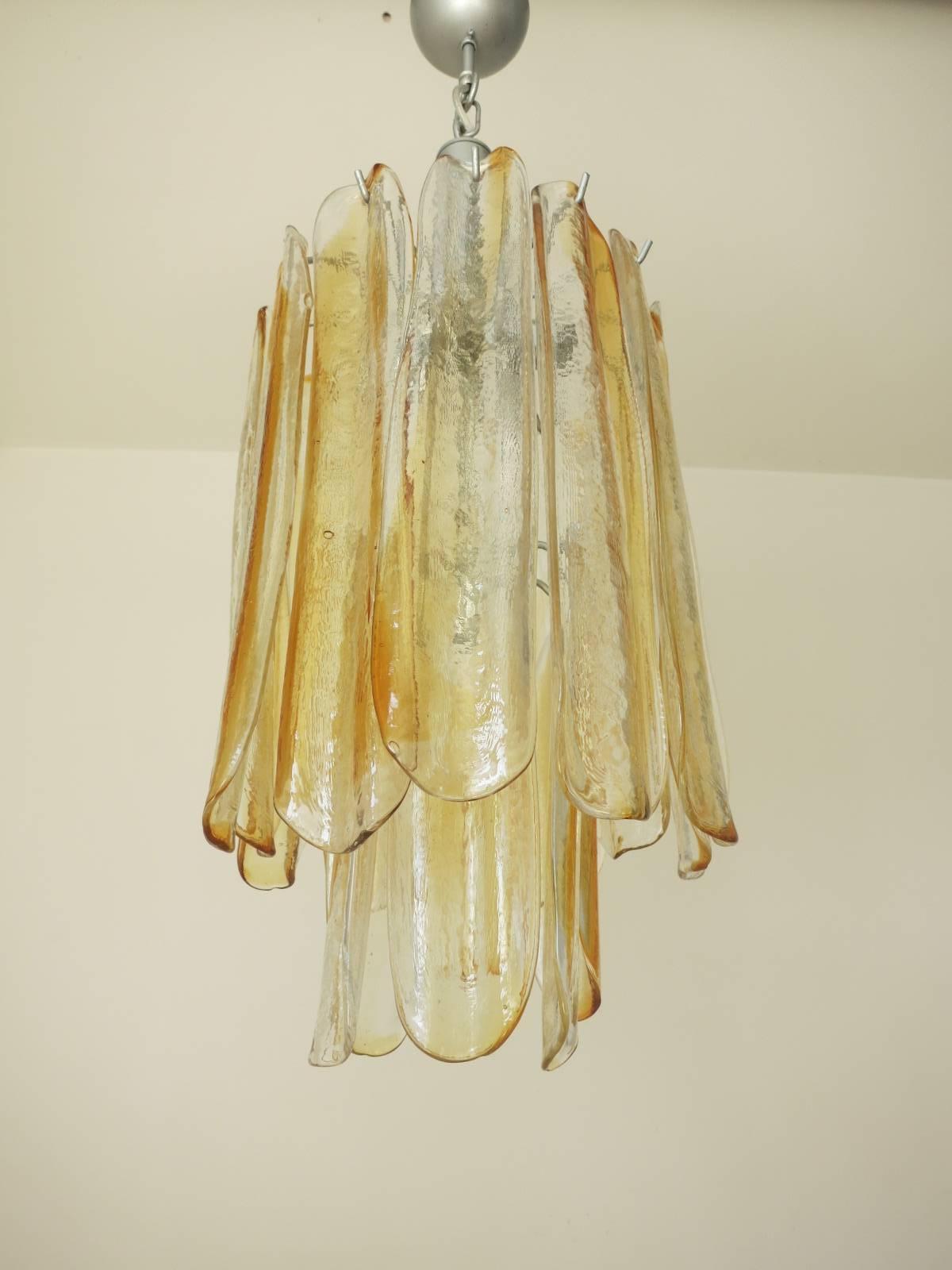 Vintage Italian chandelier with 18 infused amber and clear Murano glass pedals stacked in two tiers, mounted on nickel painted metal / Designed by Mazzega circa 1960’s/  Made in Italy
5 lights / E12 or E14 type / max 40W each
Diameter: 10 inches /