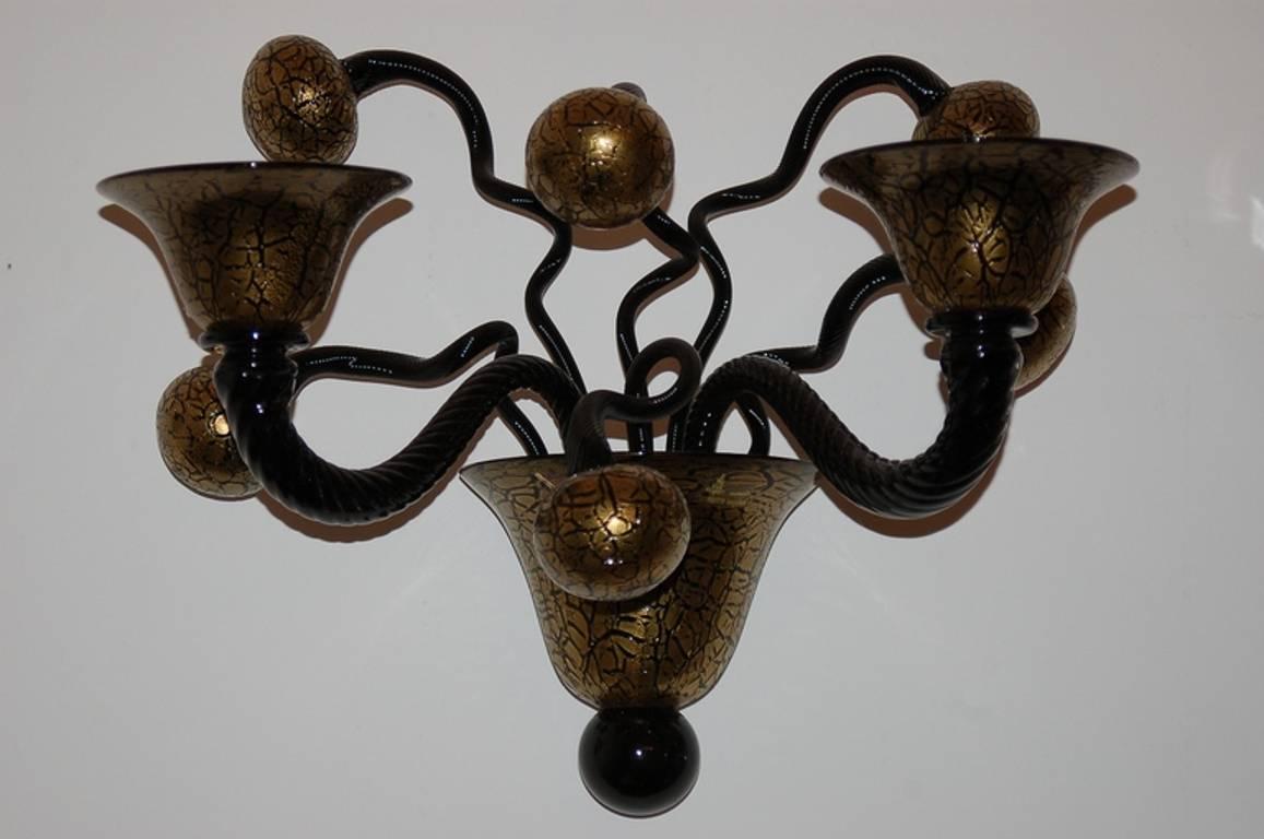 Italian traditional black and gold crackle Murano glass sconces by Maestro Gianni Signoretto circa 1980's / Made in Italy 
2 lights / E12 or E14 type / max 40W each
Height: 13 inches / Width: 12 inches / Depth: 12 inches
1 pair in stock in Palm