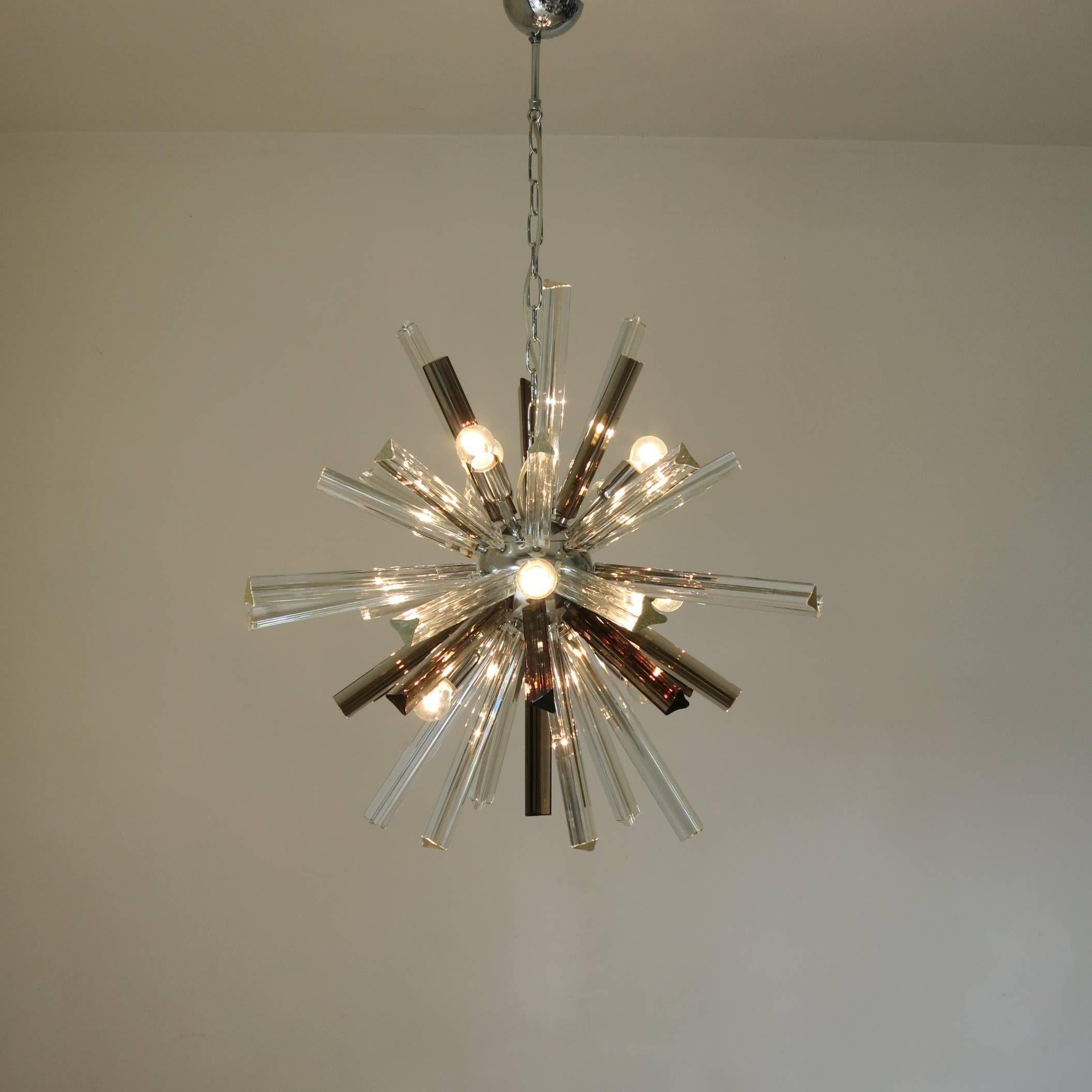 Vintage Italian chandelier with clear and smoky Murano glass hand blown into three pointed crystals using Triedri technique on chrome frame, by Venini. / Made in Italy in the 1960's,
9 lights / max 40W each
Diameter: 29 inches / Height: 26 inches