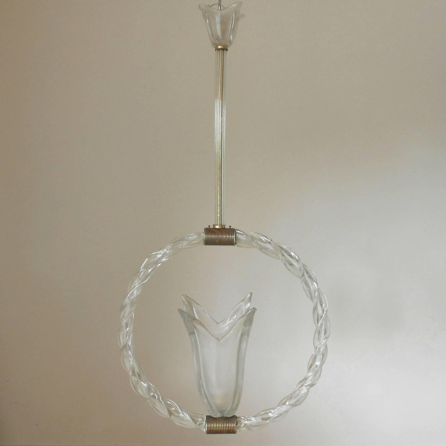 Vintage Italian pendant with a frosted Murano glass tulip surrounded by a twisted glass circle, glass rod and tulip shaped glass canopy, mounted with ribbed brass hardware / Designed by Ercole Barovier circa 1950’s / Made in Italy
1 light / E26 or