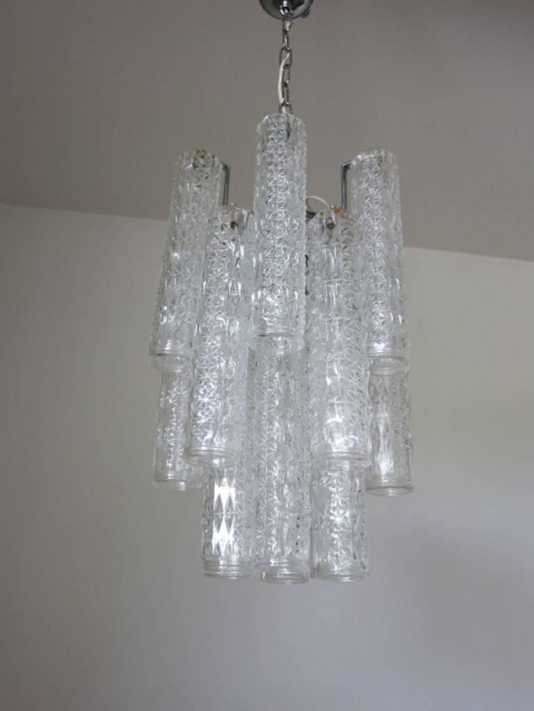 Italian vintage chandelier with clear Murano glass cylinders blown with intricate shaped patterns, mounted on chrome frame / Designed by Venini circa 1960’s / Made in Italy
4 lights / E12 or E14 type / max 40W each
Diameter: 12 inches / Height: 19