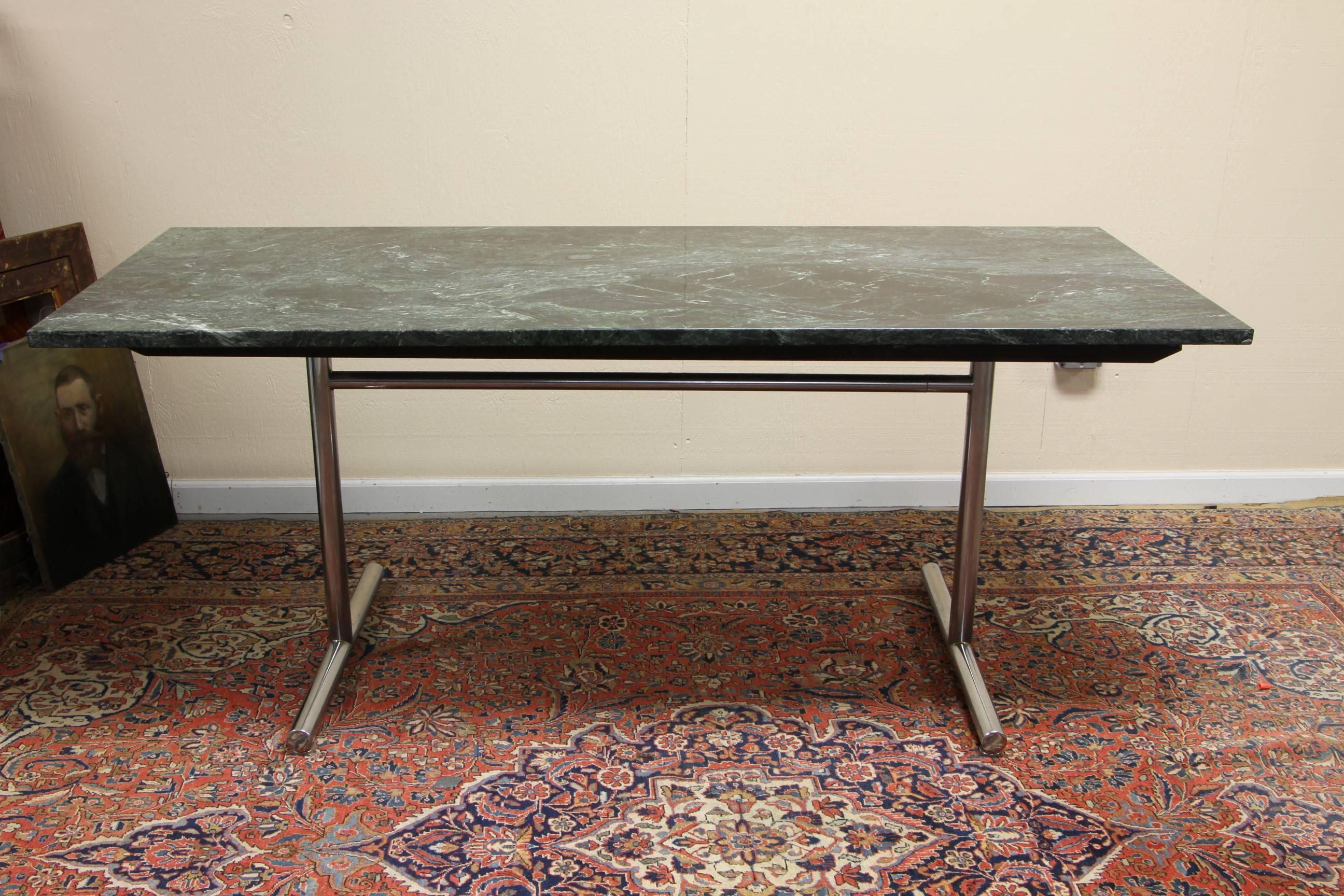With excellent proportions and very solid feeling. Green and white figured marble top on tubular chromed steel trestle base. Overall very good condition with one tiny chip to a corner.