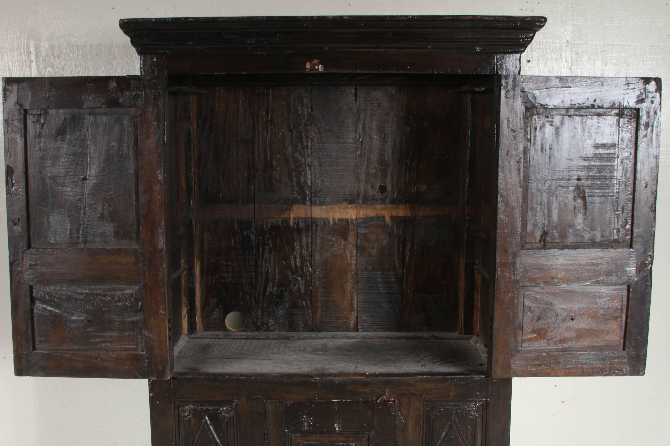 This well-made, solid and ornate armoir was converted to an entertainment cabinet, shelf has been removed and a hole was cut into the back for wiring. Rectangular starburst are carved into the two upper doors and bottom door which reveals an