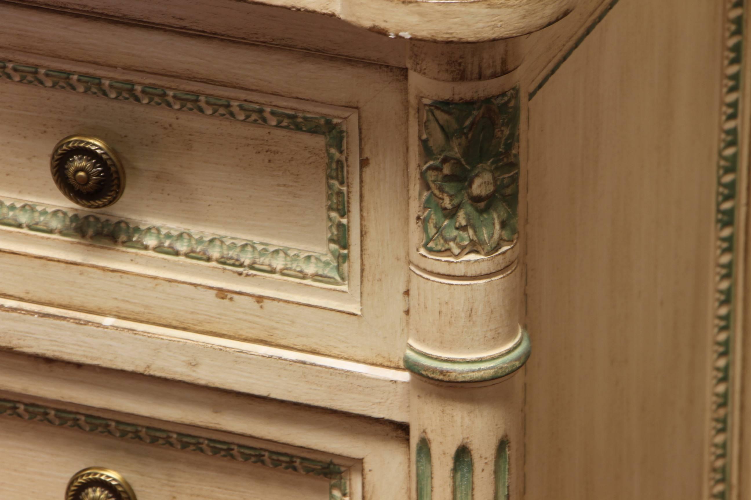 Each with three drawers, scalloped top, flanked by fluted columns, conforming glass tops. Some paint losses which enhance the distressed look overall with the exception of back on one cabinet with damage as shown.