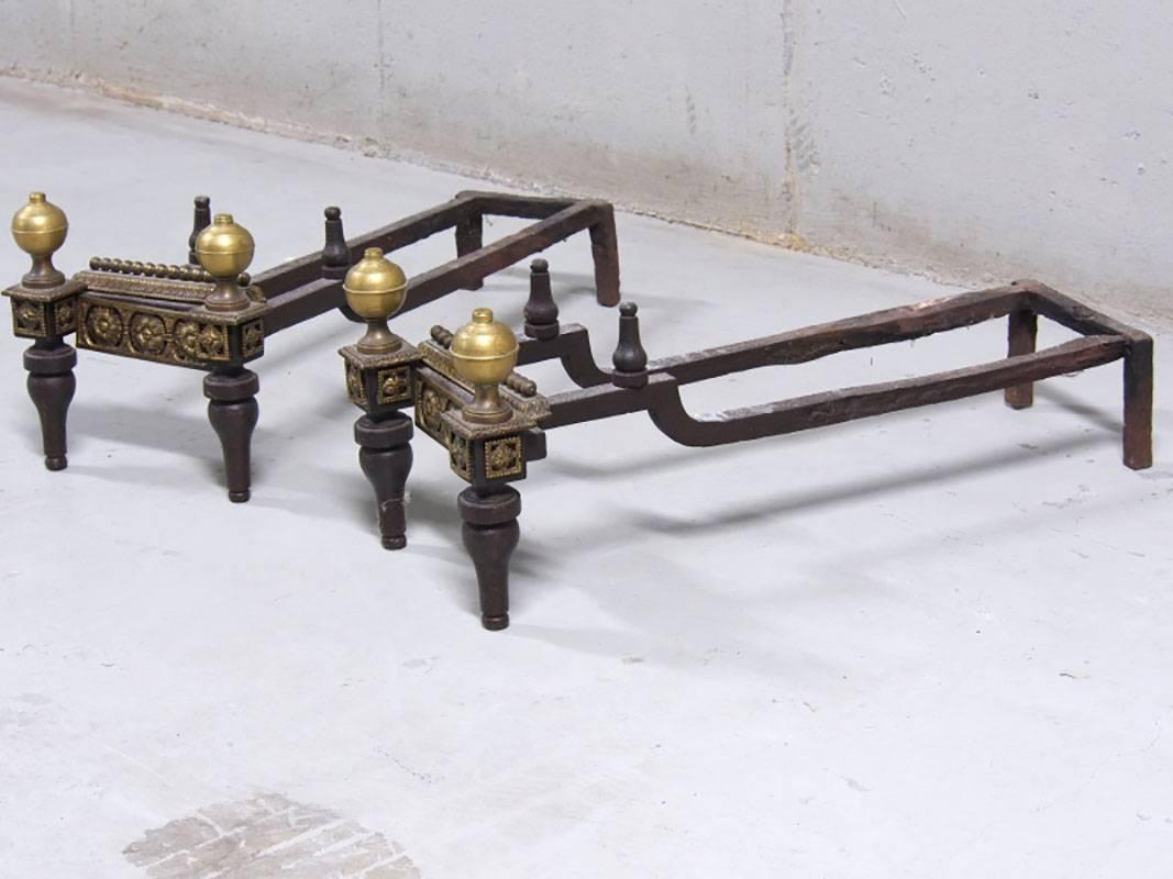 Andirons having brass and bronze neoclassical motif. Cast with beads, three floral panels across the fronts and around columns with ball finials and toupie feet. Measurements: 23 1/2