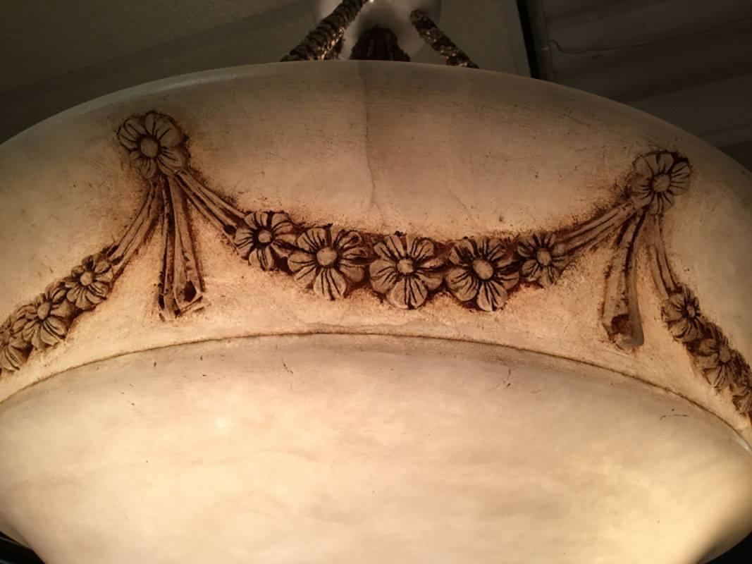 Very fine and well made Stone fixture with a fine Classical form and good color. Large alabaster pendant with highlights floral swag around edge. Light is suspended by thick woven roping. White ceramic ceiling mount. Height of main light is 10