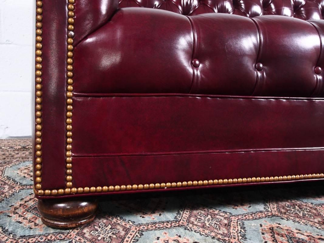 Overall tufted design with nailhead details. Sofas rest on bun feet. Slightly rolled arms. Excellent quality and very good condition. Made by Hancock and Moore.