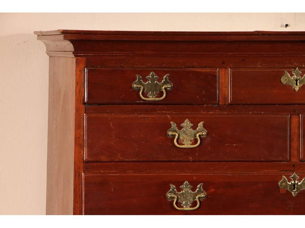 Chestnut tall chest having three over two over five full-length graduated drawers, brass hardware and escutcheons, raised on bracket feet.
Condition: Some splits as shown; condition consistent with age including some general acceptable wear.