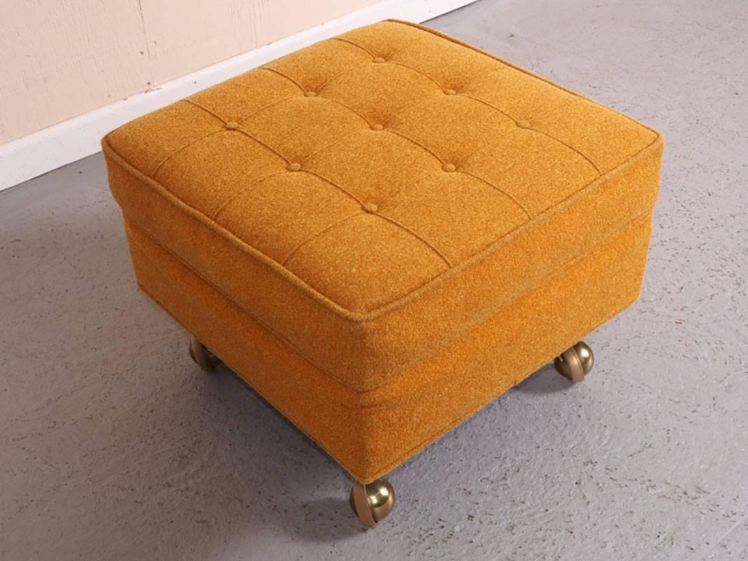 Original wool upholstery in golden color. Tufted button top. Brass casters are in smooth working condition. Interior padding may be drying.