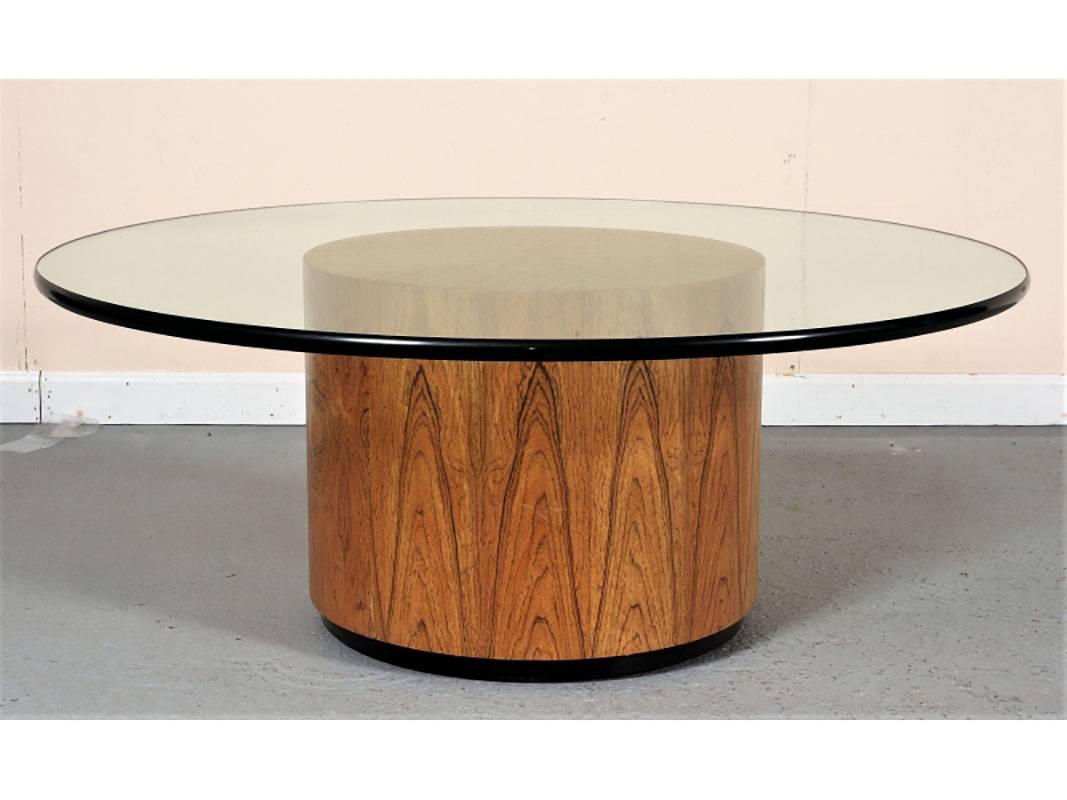 Iconic Mid-Century Modern cocktail table designed by Harvey Probber. Round glass top table with rounded edge atop a round wood base with pretty grain with recessed casters. Base measures 19 1/2" diameter. Glass measures 3/4" in thickness.