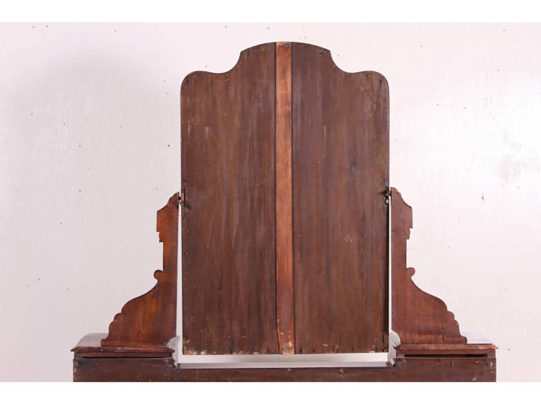 A heavily carved vanity/desk made from select burl wood. Yoke shaped stretcher at bottom. Fitted with small drawers on sides. Attached mirror. Very good condition and a not often seen form. There are three missing knob escutcheons.
