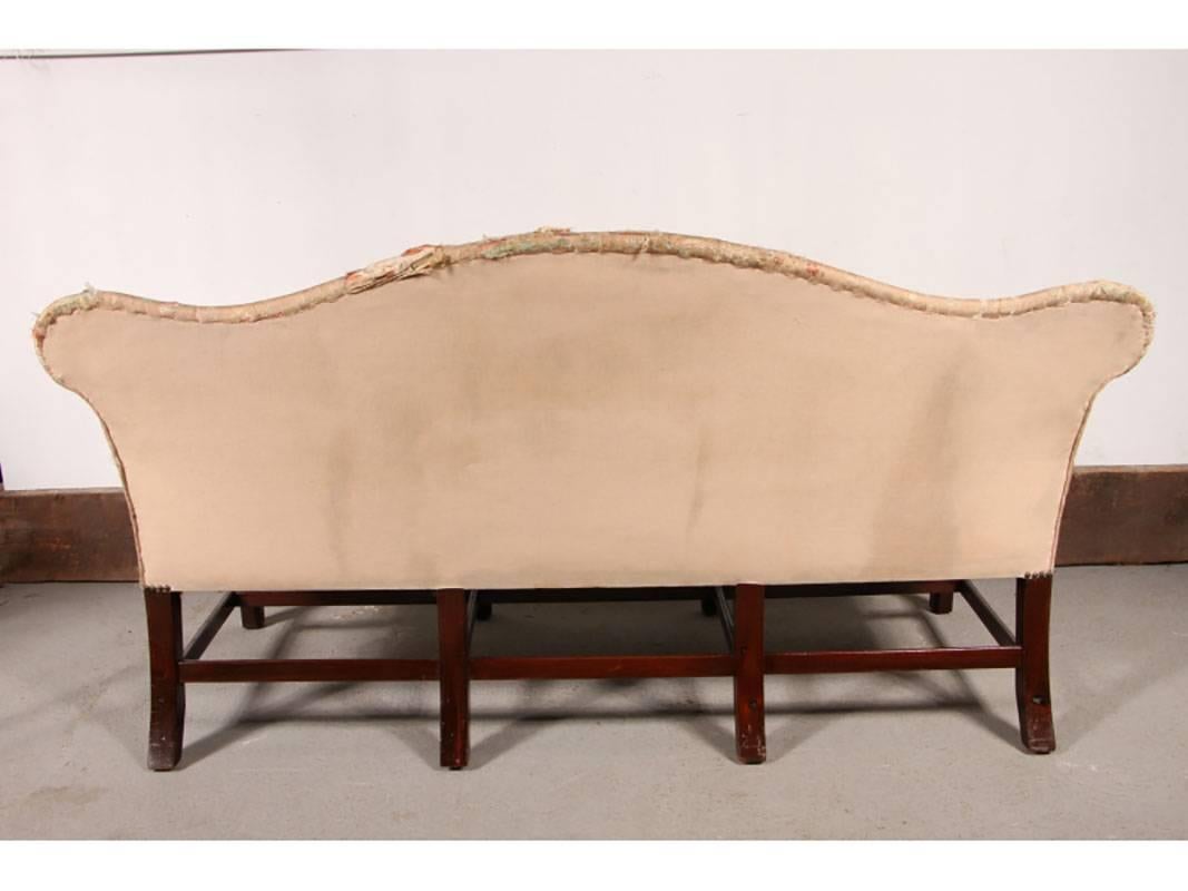 Settee with camel back having rolled arms with brass tack decoration over a rectangular shaped seat raised on stop-reeded mahogany block legs with triple H-stretcher supports.
Condition: Needs upholstery.