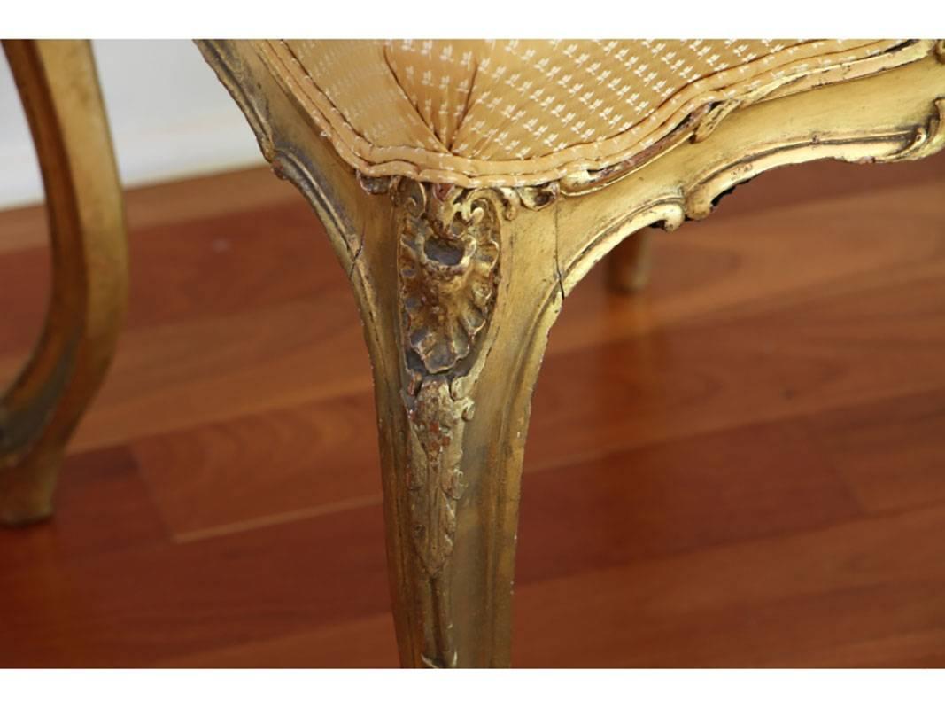 Pair of antique chairs with gilded paint decoration and golden fabric upholstery with excellent form and in very good condition with minor age split to the wood.