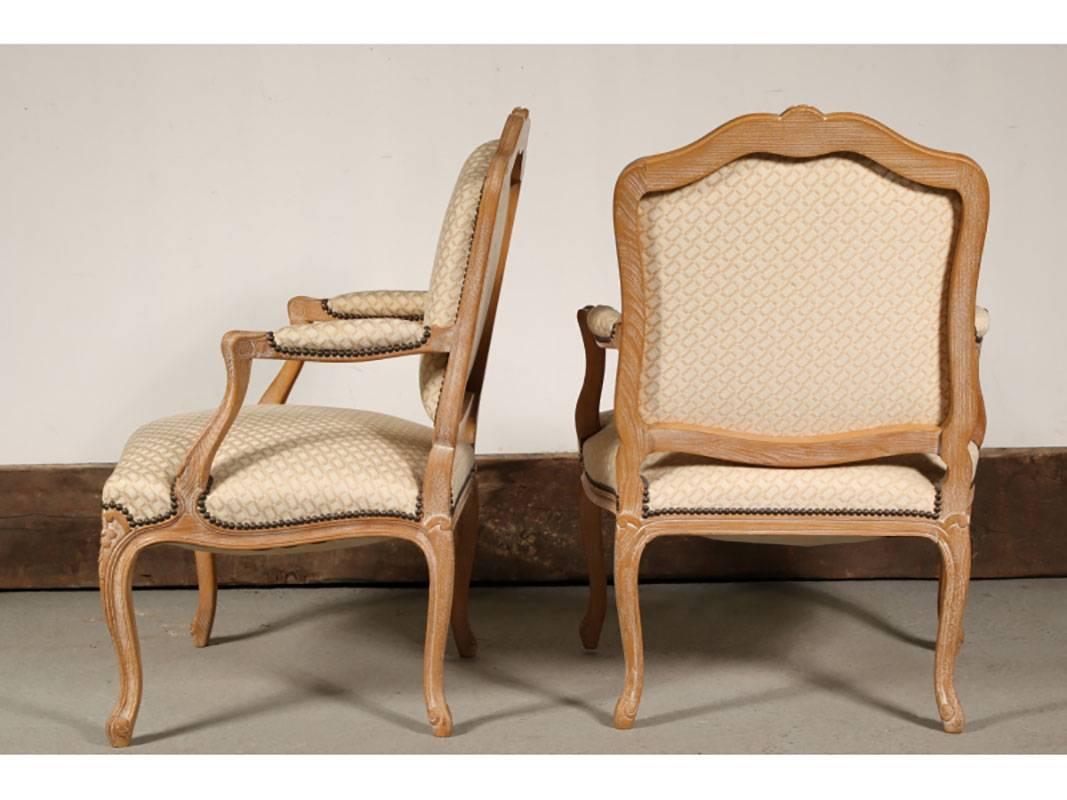 Pair of vintage beige tonal fauteuils in carved frames with brass nailhead trim.
Condition: one chair with tiny puncture to back, few light spots to both seats.
