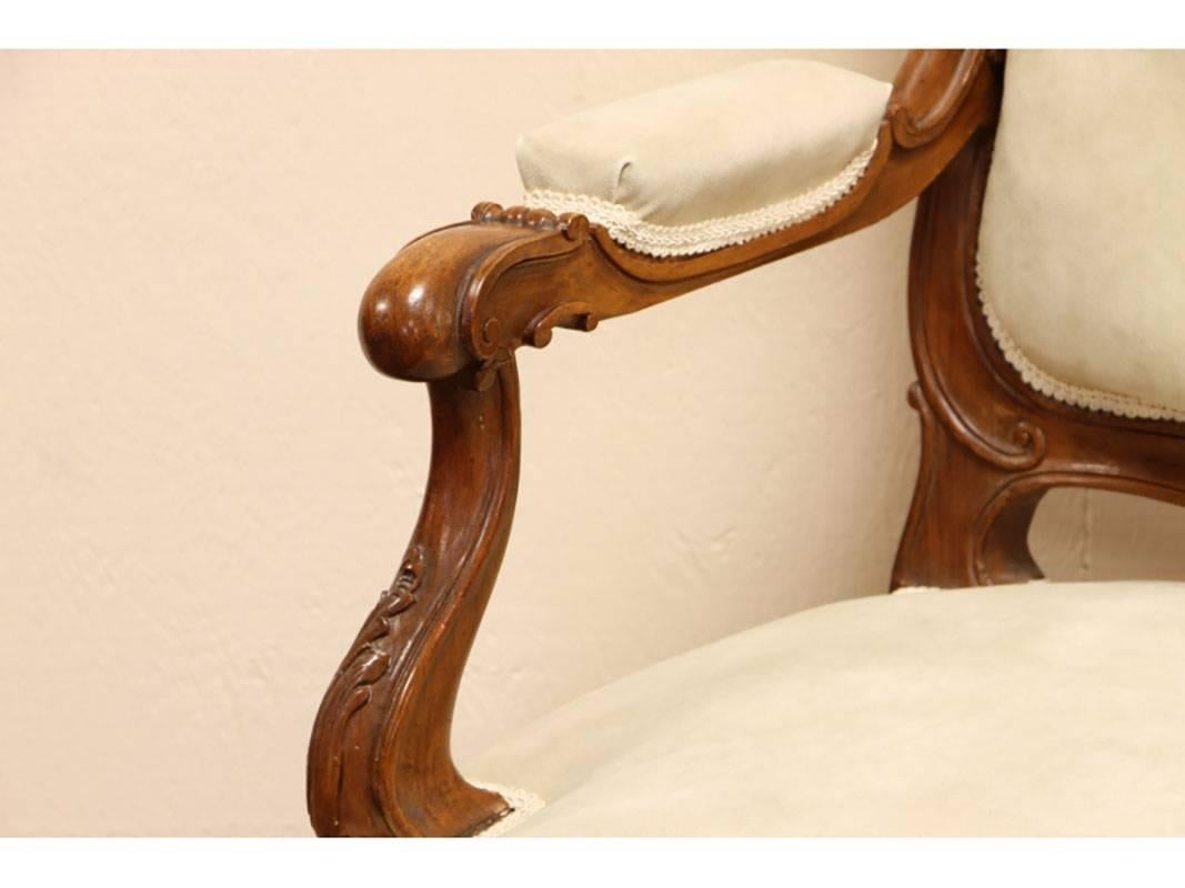 A finely carved walnut frame with Cabriole leg and shell crest with cream faux suede upholstery.