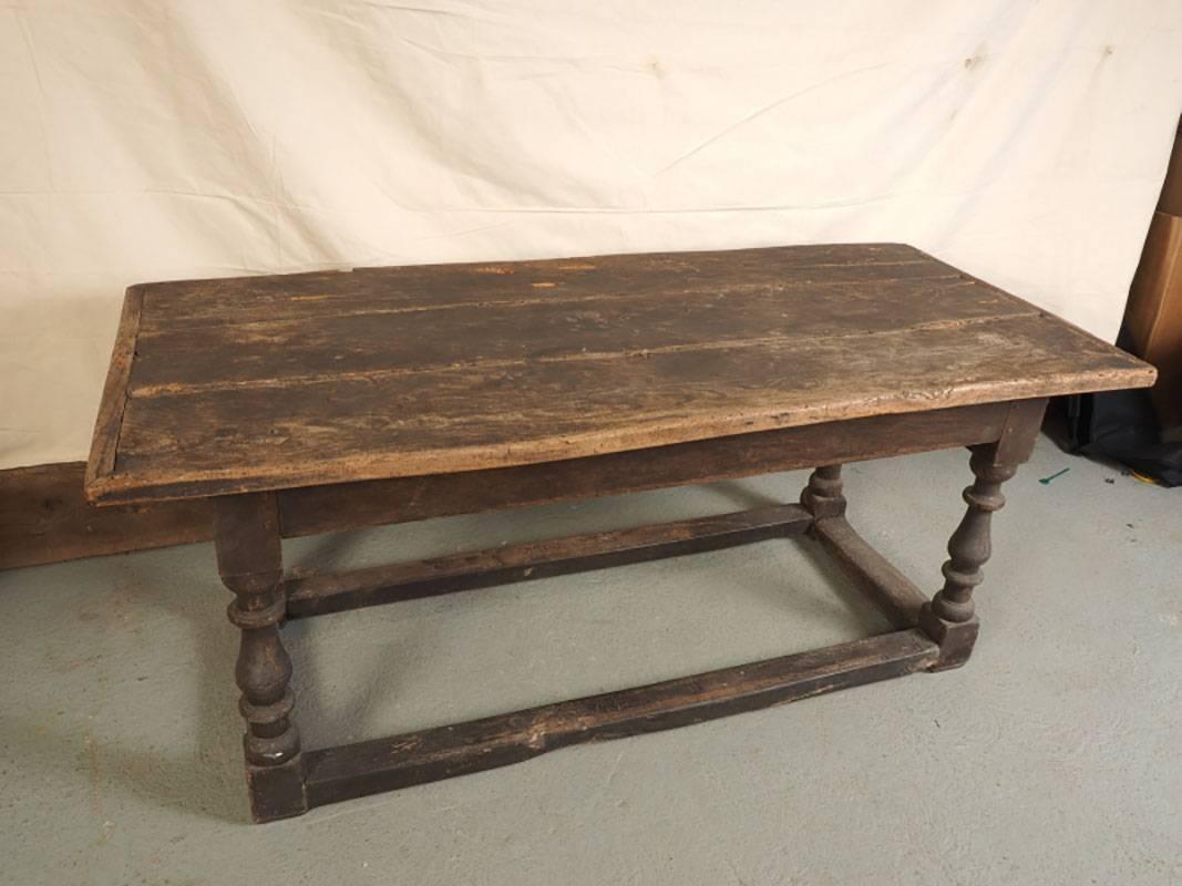 Early and extraordinary plank top table in all original condition. With great proportions, stretcher base, turned legs, mortise and tenon joinery and breadboard top. Extensive age appropriate wear including worming marks, slight chips and rubs.
