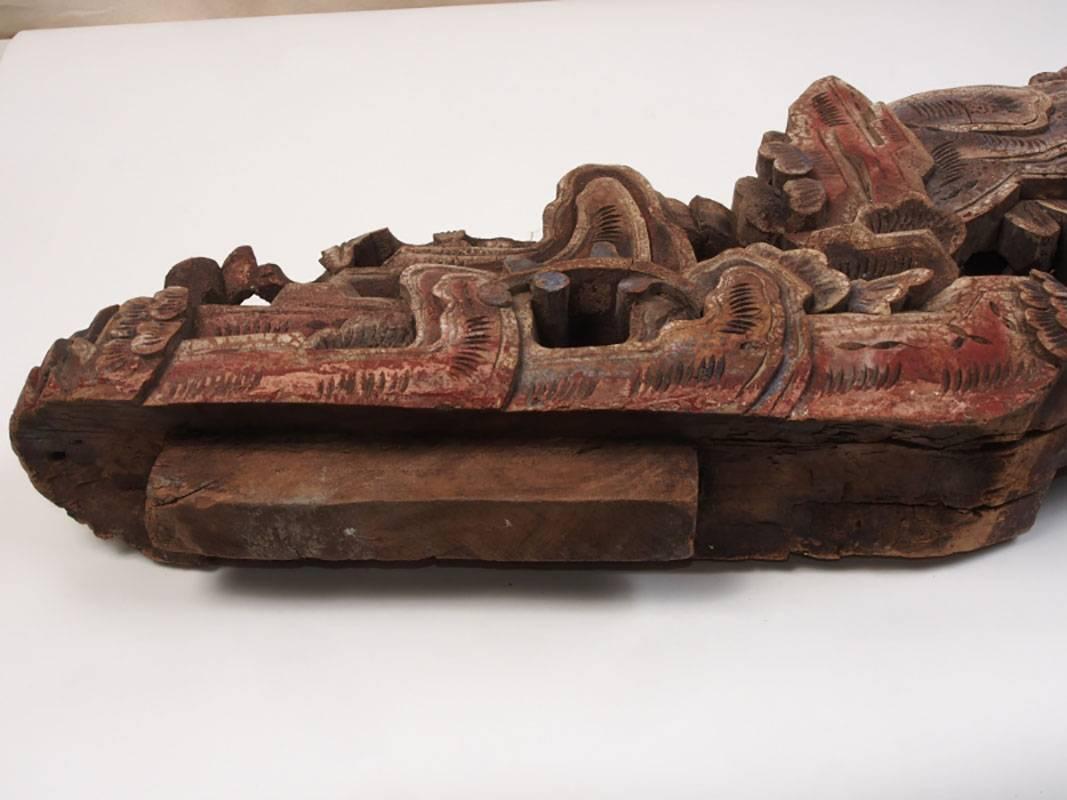Pair of antique carved wood figural corbels with a Chinese elder mounted on a small animal and holding a bitten piece of fruit. The elder is under and between a foliate tree. The verso is comprised of more foliage and carvings. Top and bottom are