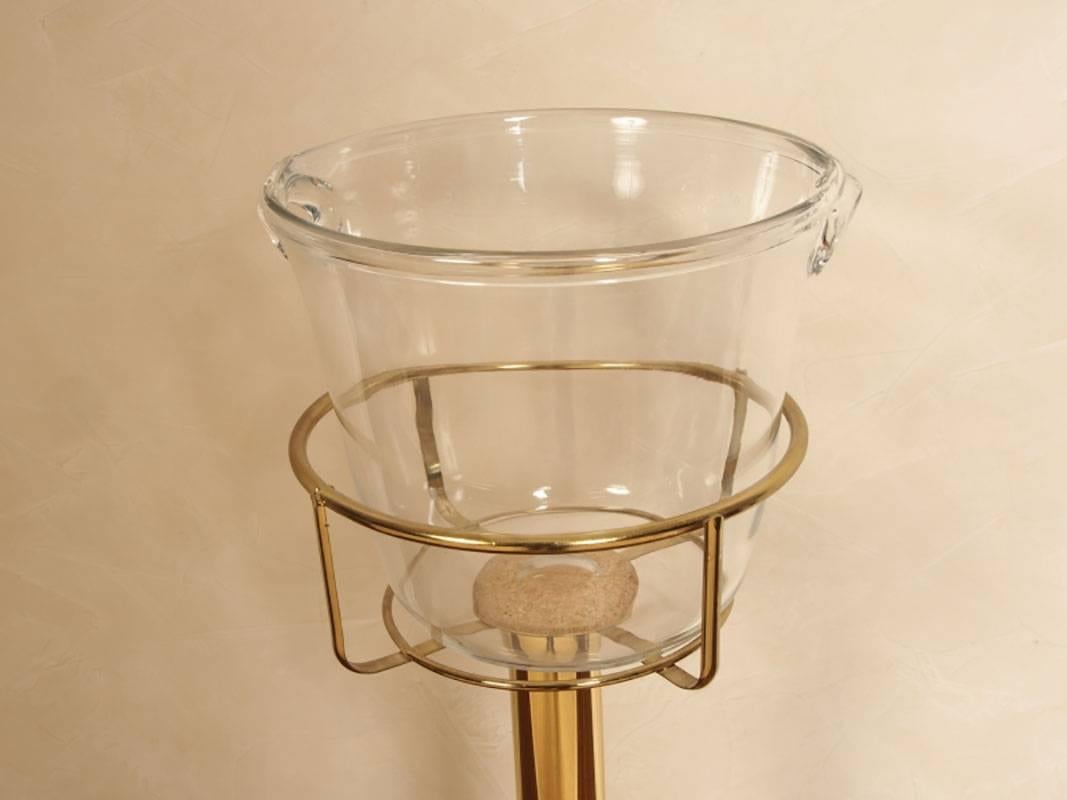 Brass-plated cylindrical Stand with cradle holding a crystal ice pail having two inset handles. 
Condition: Base with some wear and spotting.