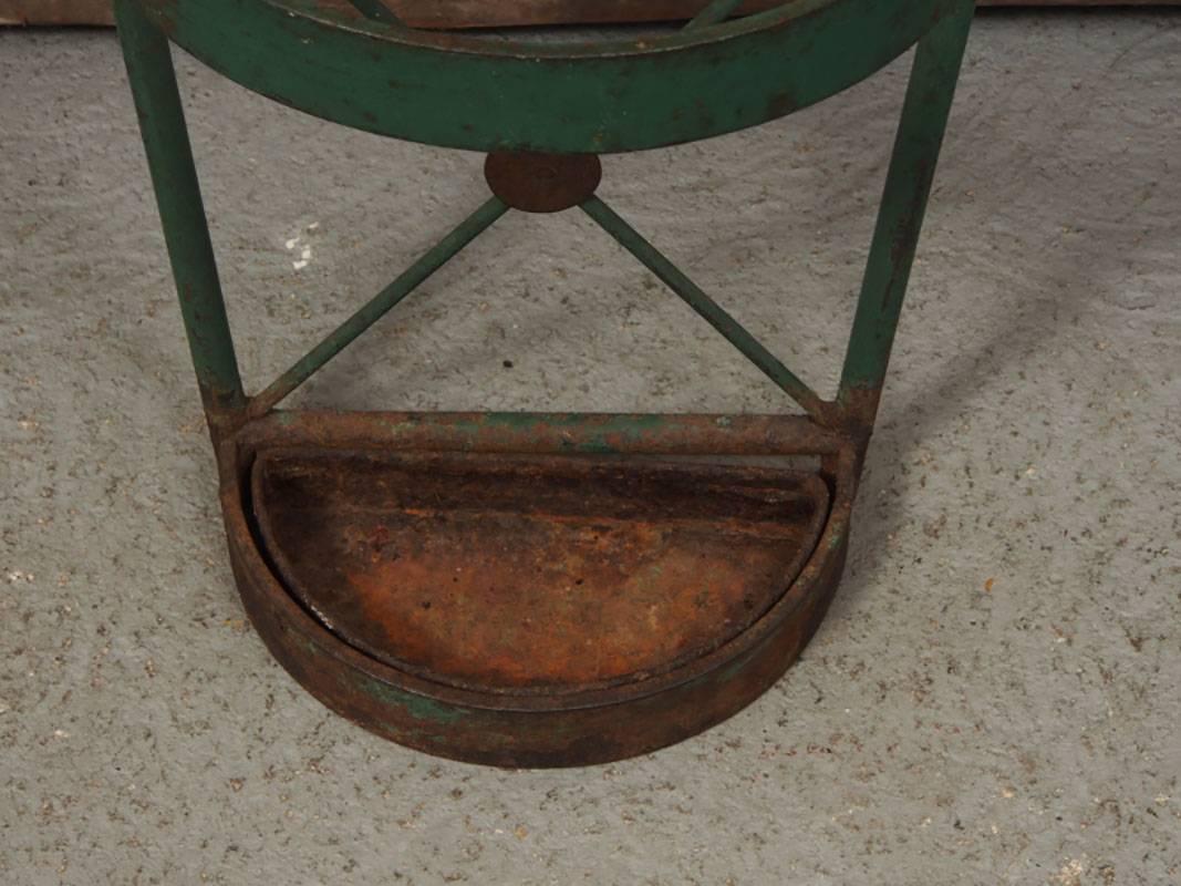 Green paint decorated wrought iron umbrella stand with
Good weight and color, tapering form, swirled crest and separate well.
Condition: tray is rusted, wear to bottom, consistent with age and use.