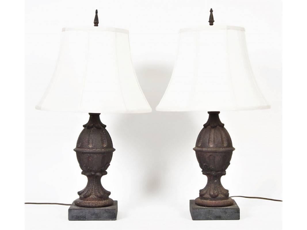 Acorn form cast iron finials with leafy tops and bases, mounted as table lamps on square stone bases. With iron pointed finials.
Condition: Overall very good with expected patina, loss to one leaf point.