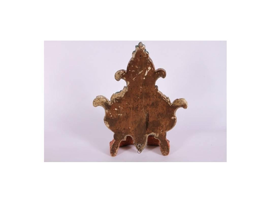 Crown above a cartouche form medallion decorated with acanthus leaves and swirls, paint decorated and gilt embellished. Hook on verso.
Condition: Small chips and losses throughout consistent with age.