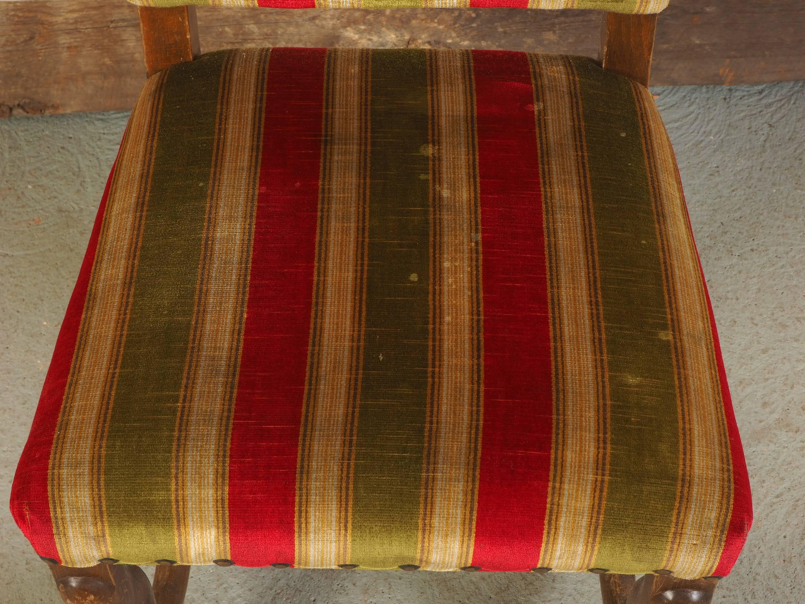 Feature solid walnut frames upholstered in a plush red and green striped fabric and nail head trim. Legs show wear and scratches, and the upholstery is a bit dry and exhibits overall light staining.