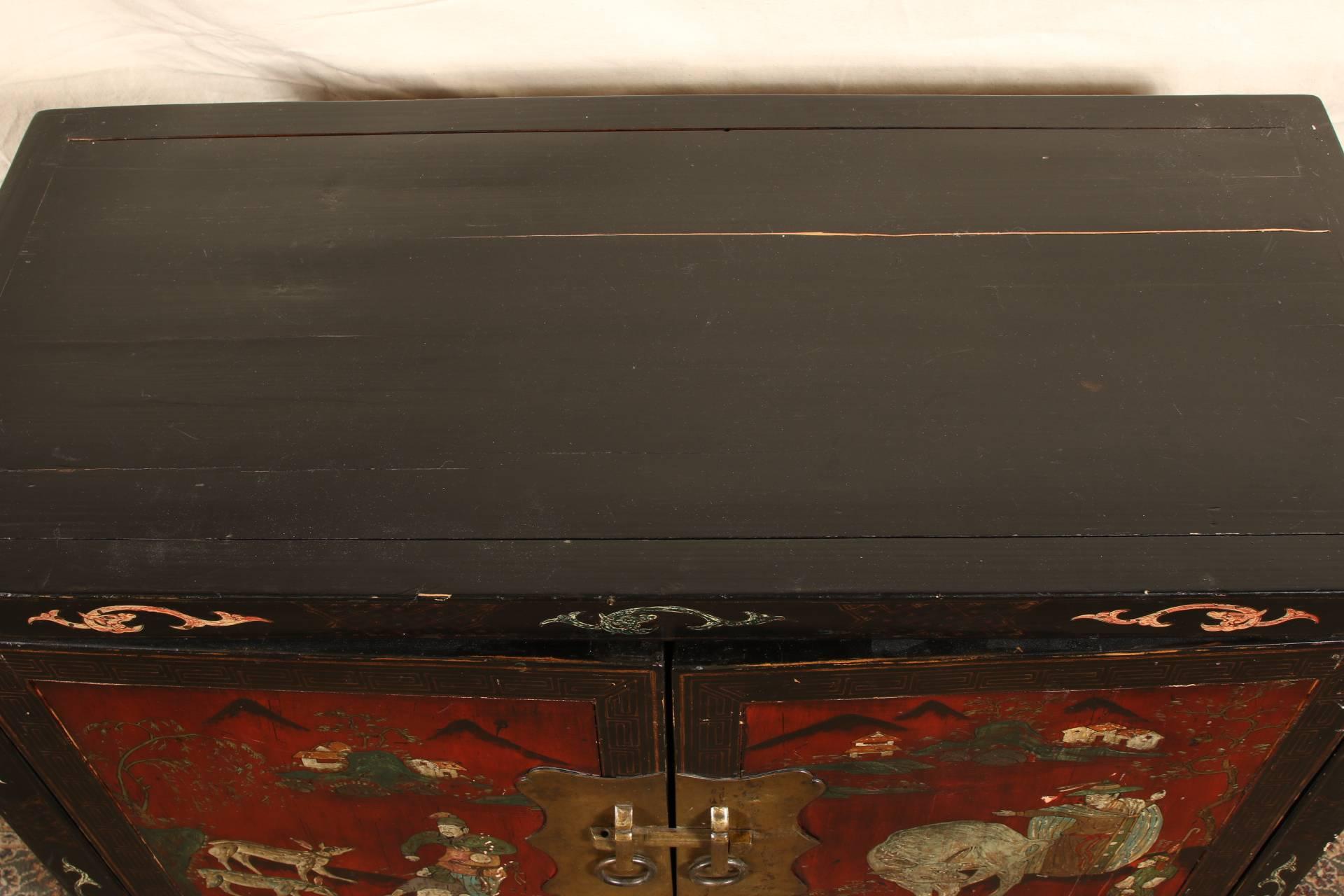 Ebonized double door cabinet with paintings of figures and animals in a landscape. The borders and shaped base with painted symbols. The interior with a single shelf. Brass hardware.
Condition: some scratches and wear to the paint.