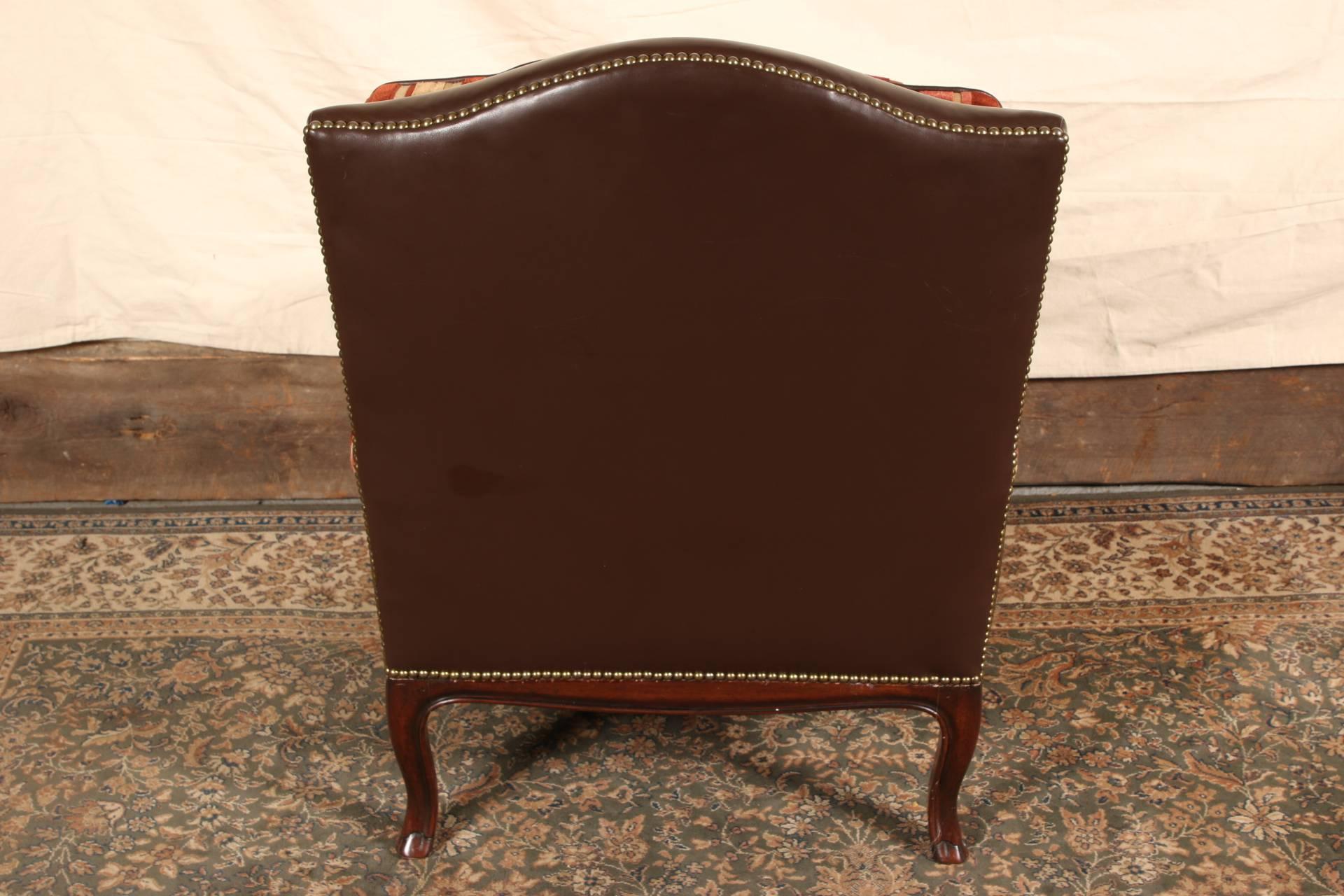 Brown leather with nailheads overall, carved mahogany arms, shaped aprons and cabriole legs. Upholstered in striped cut velvet in pink and burgundy tones.