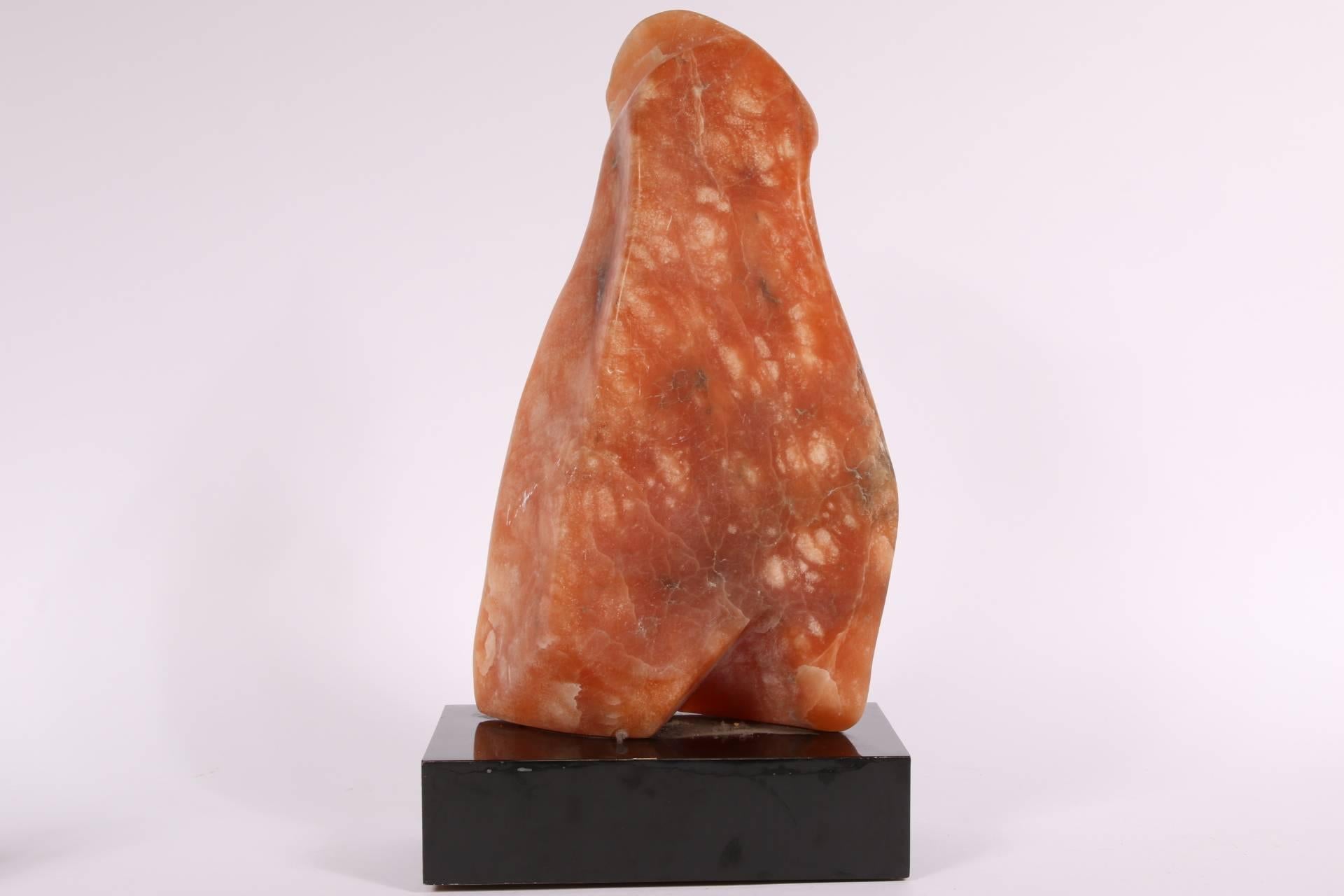 Coral color stone depicting an abstract sculpture, mounted on a black rotating plinth base. Bears brass plaque with title
