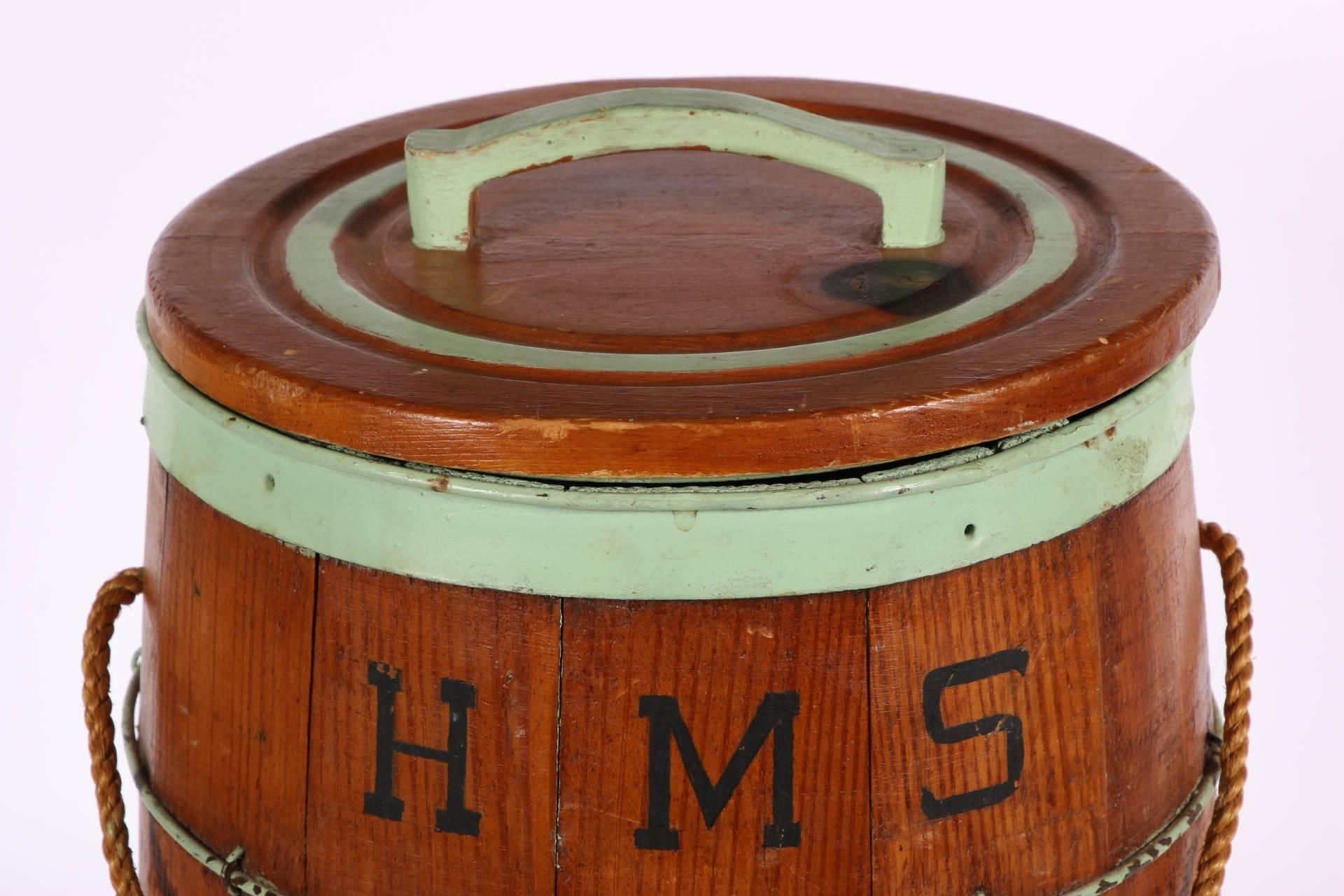 Antique barrel form nail box having green paint decorated iron binding, panelled construction, painted HMS Bounty, 1789. Rope cord handle, green paint decorated interior.
Condition: some rust, consistent with age and use.