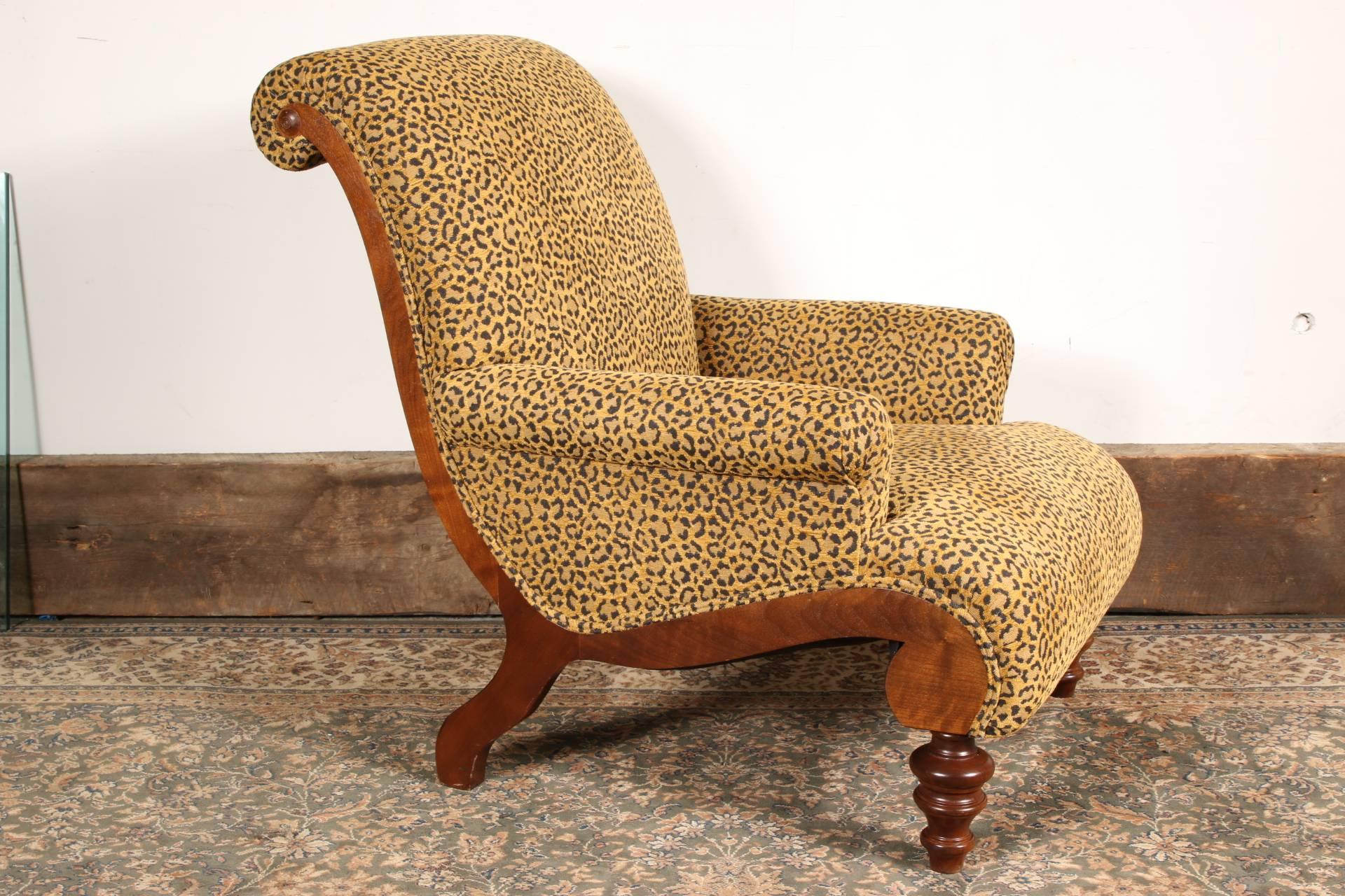 With a scrolled mahogany frame with turned front legs, and upholstered in a tan and black animal print with rolled arms. Very good condition with only very minor wear.