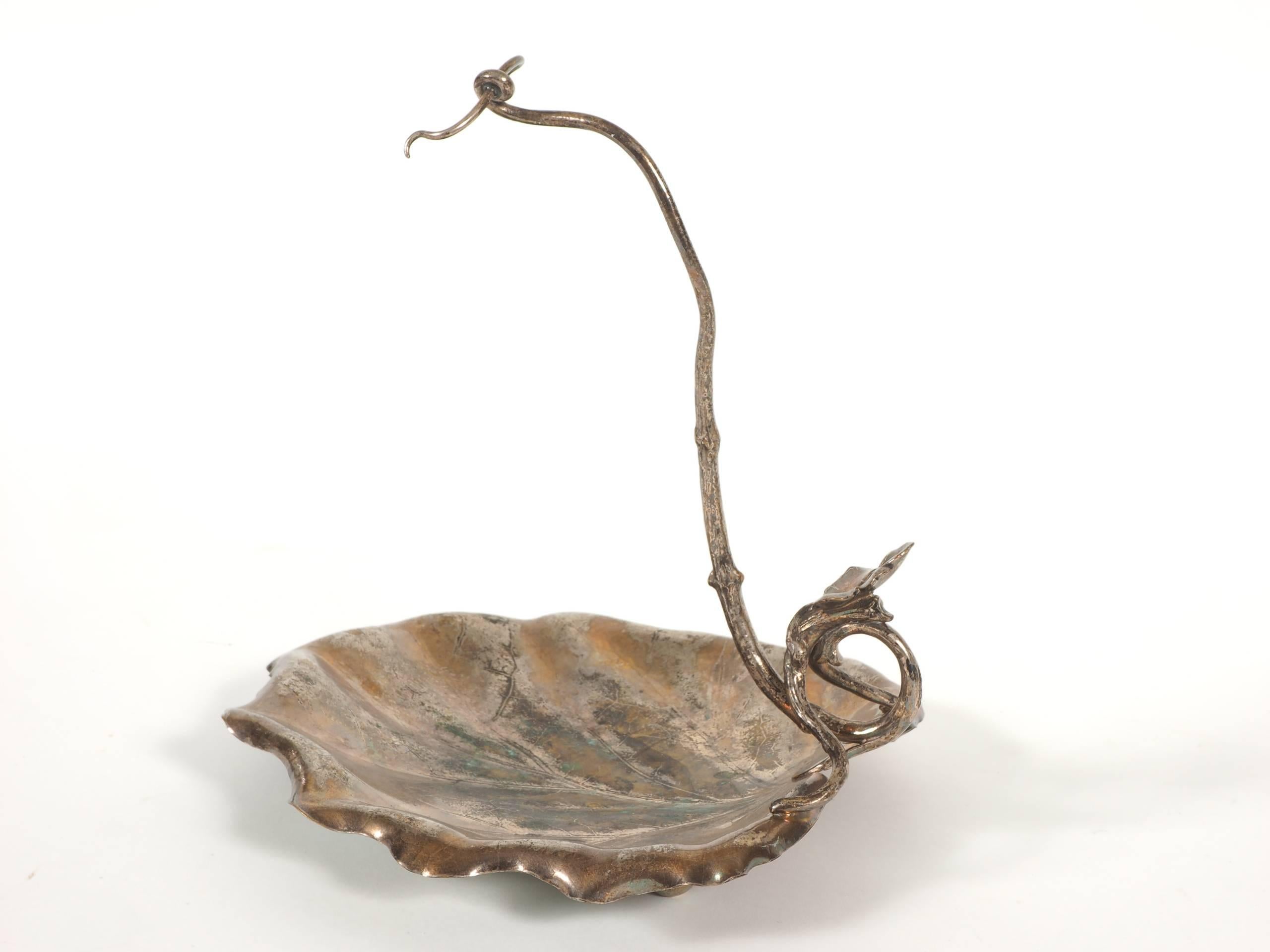 Antique Christofle silver plate grape rack with a leaf form tray and a scrolling vine terminating with two coils. Hallmarked on base of vine with '20', 'figural hallmark with scales of justice,' and 'Christofle in a rectangle.' Additionally stamped