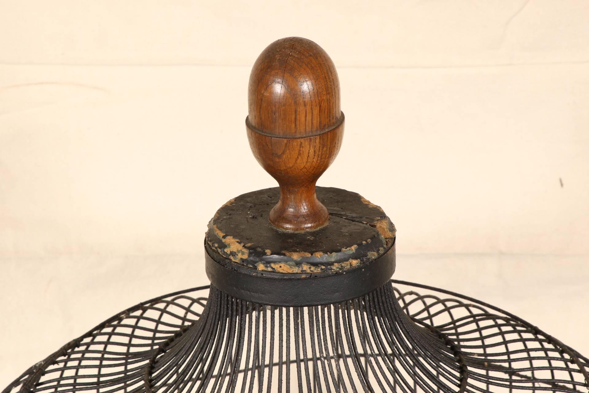 Ebonized wood base and top with turned walnut finial. The black wire cage with canted corners ad two cup windows with one copper cup preserved. A single door. The base is open below the wire bottom.
Condition: Chipped top, worn base.
