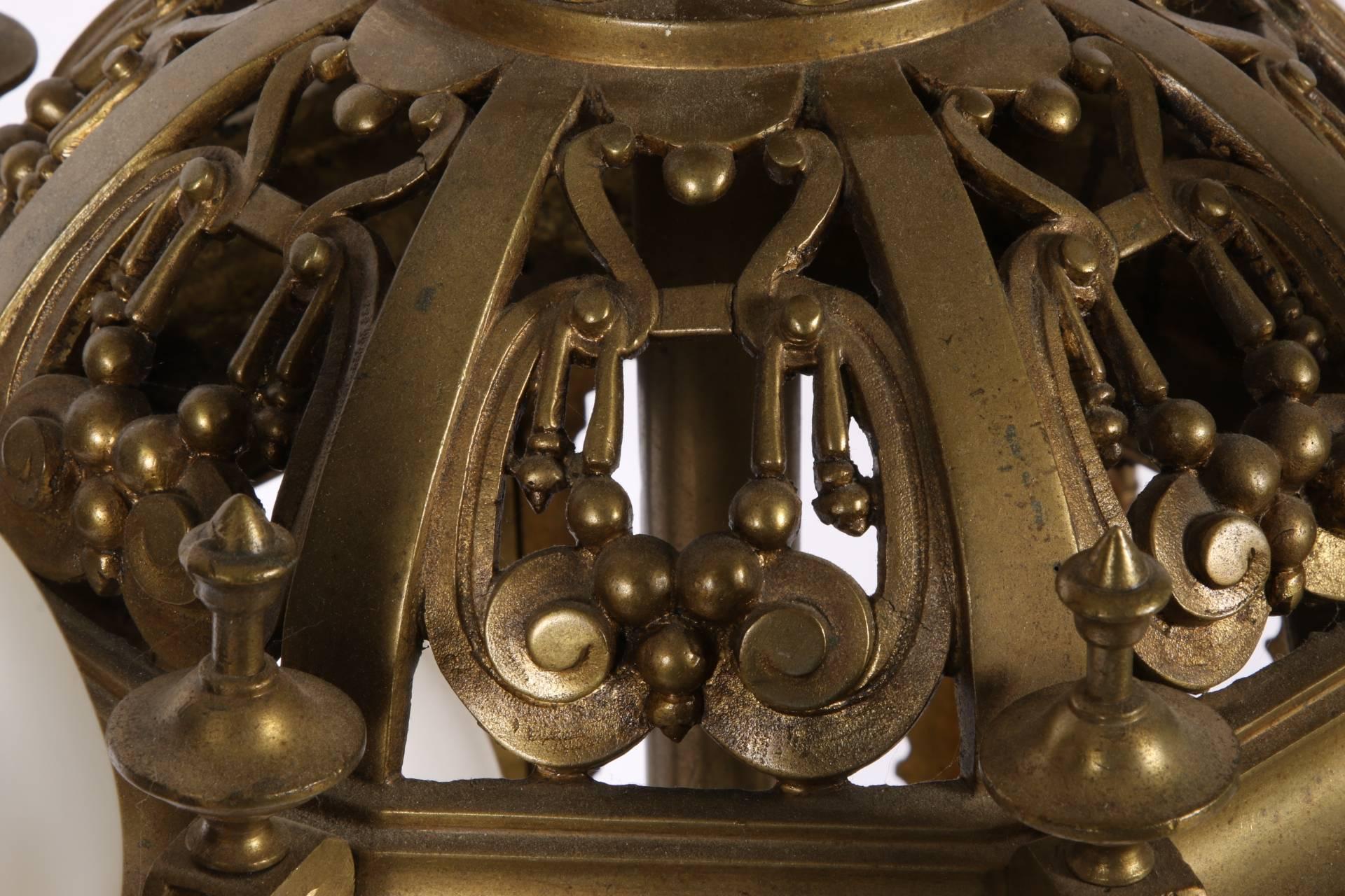Cast bronze octagonal openwork form with three interior lights and four outer attached openwork arms with candle socket lights. A domical openwork top with column supports for the upper tiers and a leafy finial. Mounted on a tall base screwed onto a