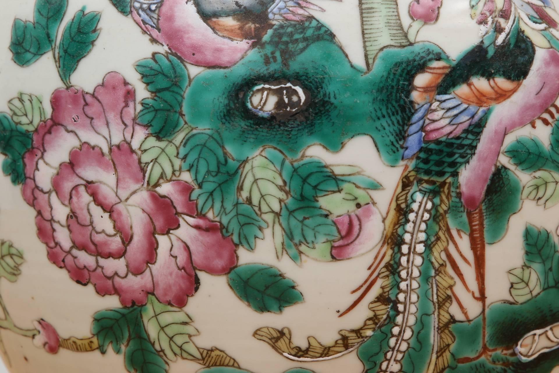 Famille verte and rose tones decorated with confronting exotic birds in flowering trees on the front and butterflies on the backs. The knobbed lid with flowers and a butterfly.
Condition: chips to the knob.