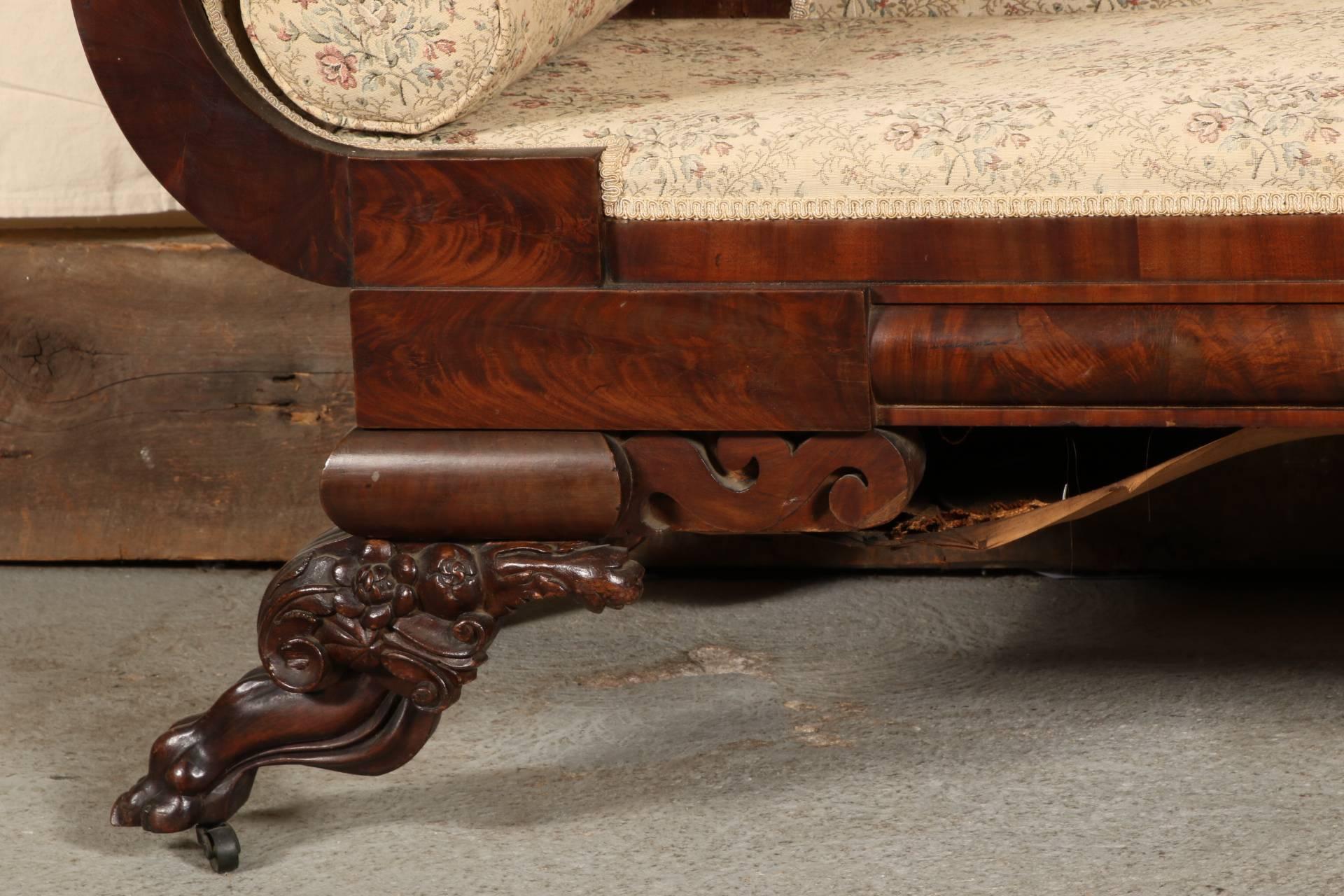 Burled wood frame with exaggerated scrolled back and arms. The crest rail carved with acanthus leaves, and raised on heavy carved lion's paw legs with scrolled foliate decoration. On casters.
Condition: Bottom of the sofa will have to be re-sprung.